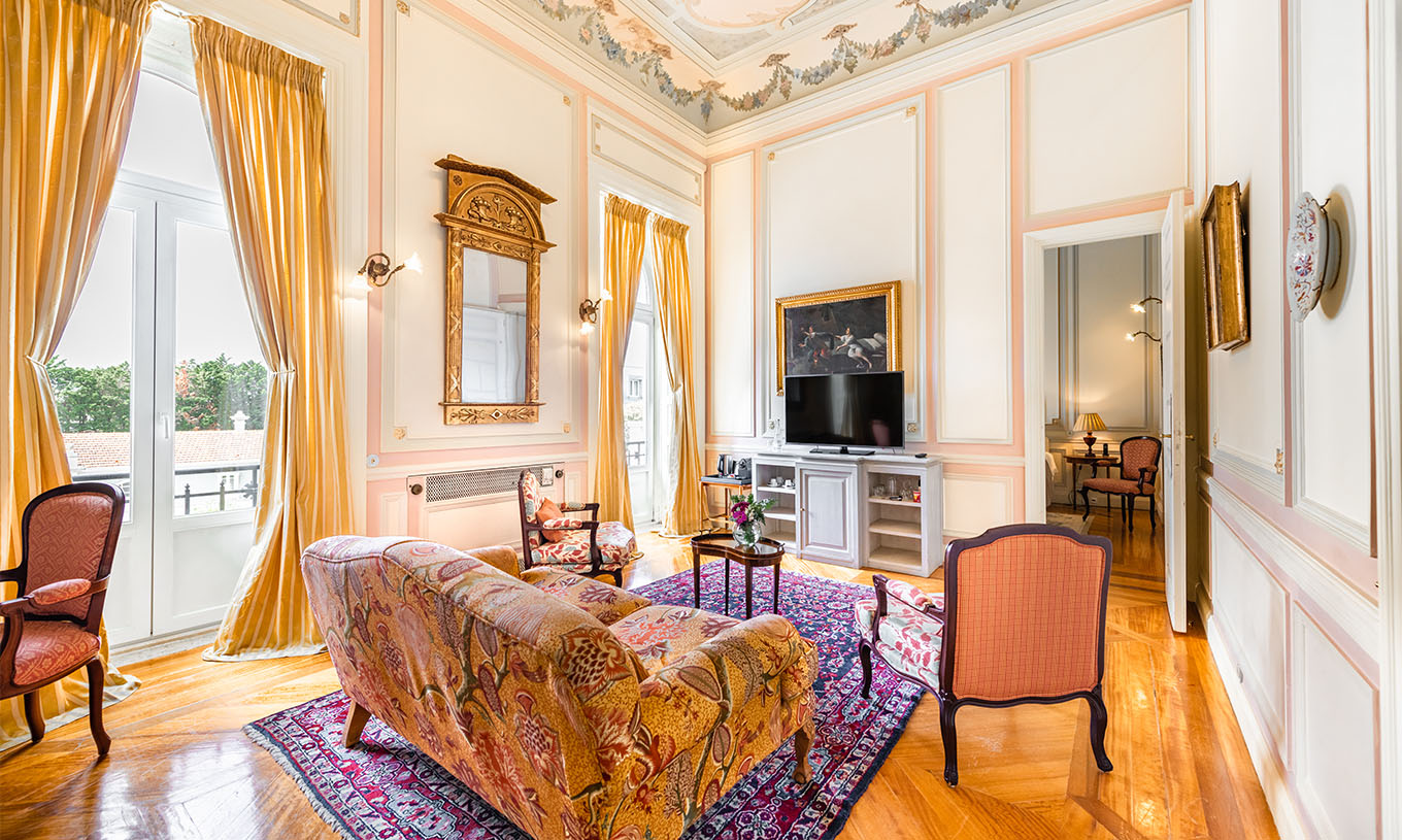 De Suite D. Amélia van Pestana Palace Lisboa heeft een woonkamer met bank, stoelen, televisie en twee grote ramen