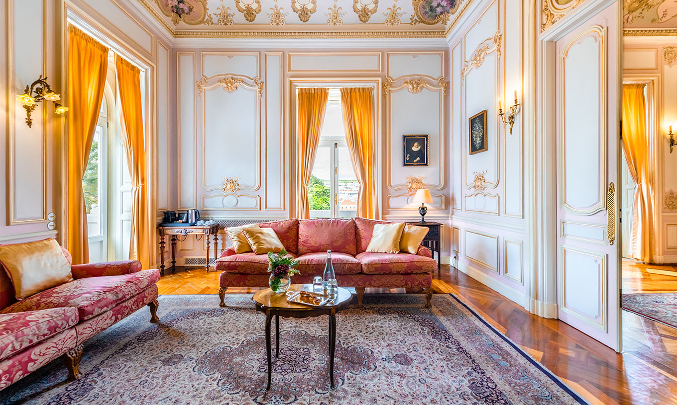 De Suite D. Carlos van Pestana Palace Lisboa heeft een grote luxe woonkamer met twee banken, tapijt en twee ramen