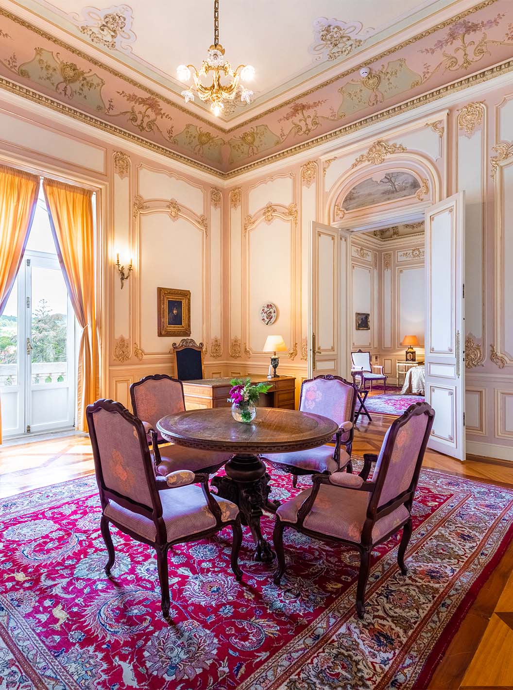 De Suite D. Carlos van Pestana Palace Lisboa heeft een grote luxe salon met een raam en een tafel voor maaltijden