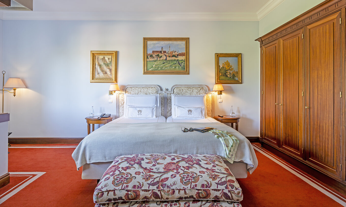 De Suite van Pestana Palace Lisboa heeft een tweepersoonsbed met een bank aan het voeteneinde van het bed en een grote kast