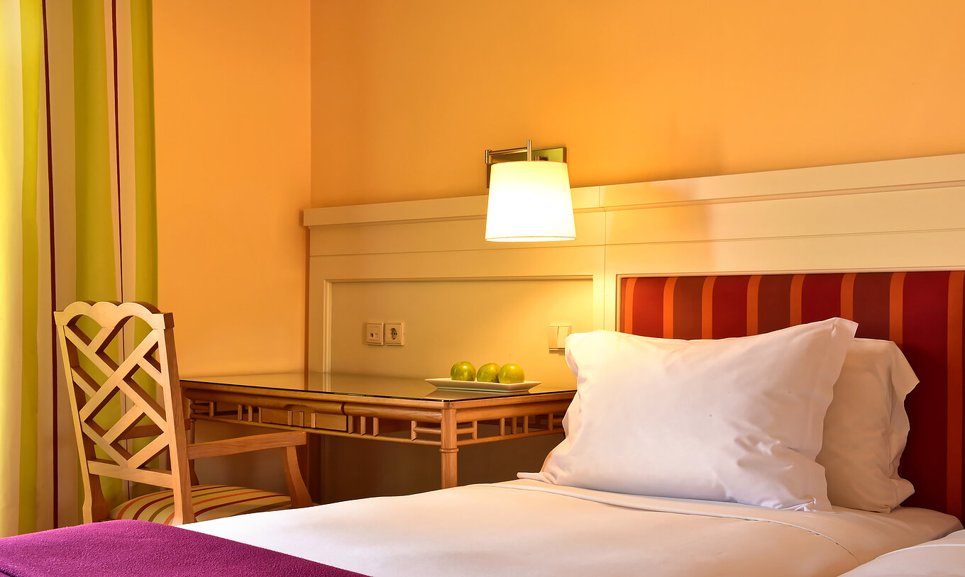 De Klassieke Tweepersoonskamer - Tuinzicht van Pestana Sintra Golf heeft een bed met witte lakens en een bureau met stoel