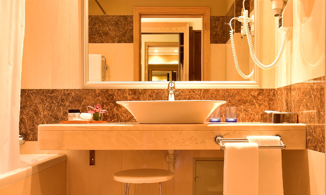 De Classic Twin Pool View van Pestana Carlton Madeira heeft een badkamer met bruine tegels en een bad