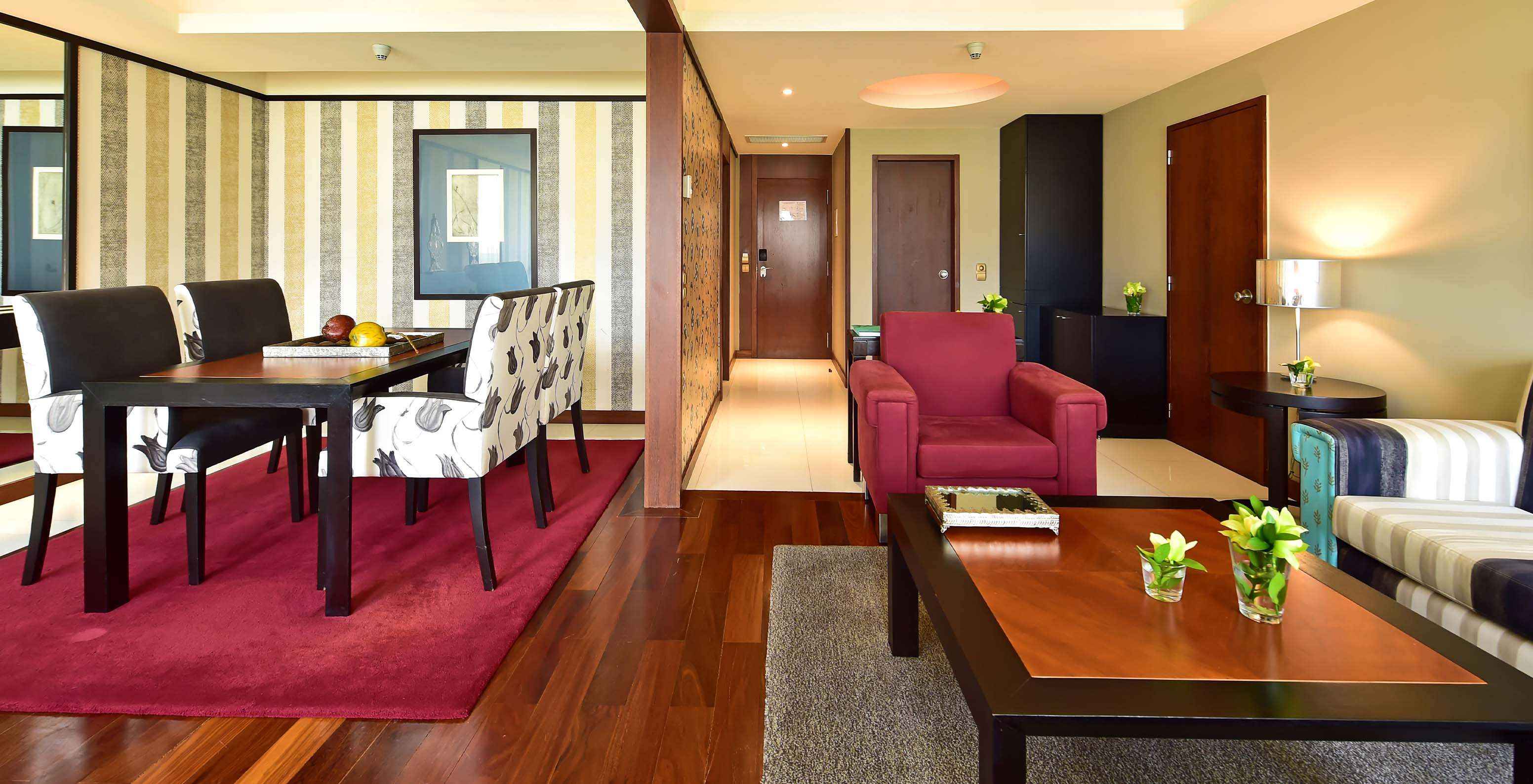 De Presidentiële Suite van Pestana Casino Park heeft een woonkamer met eettafel, bank en fauteuil