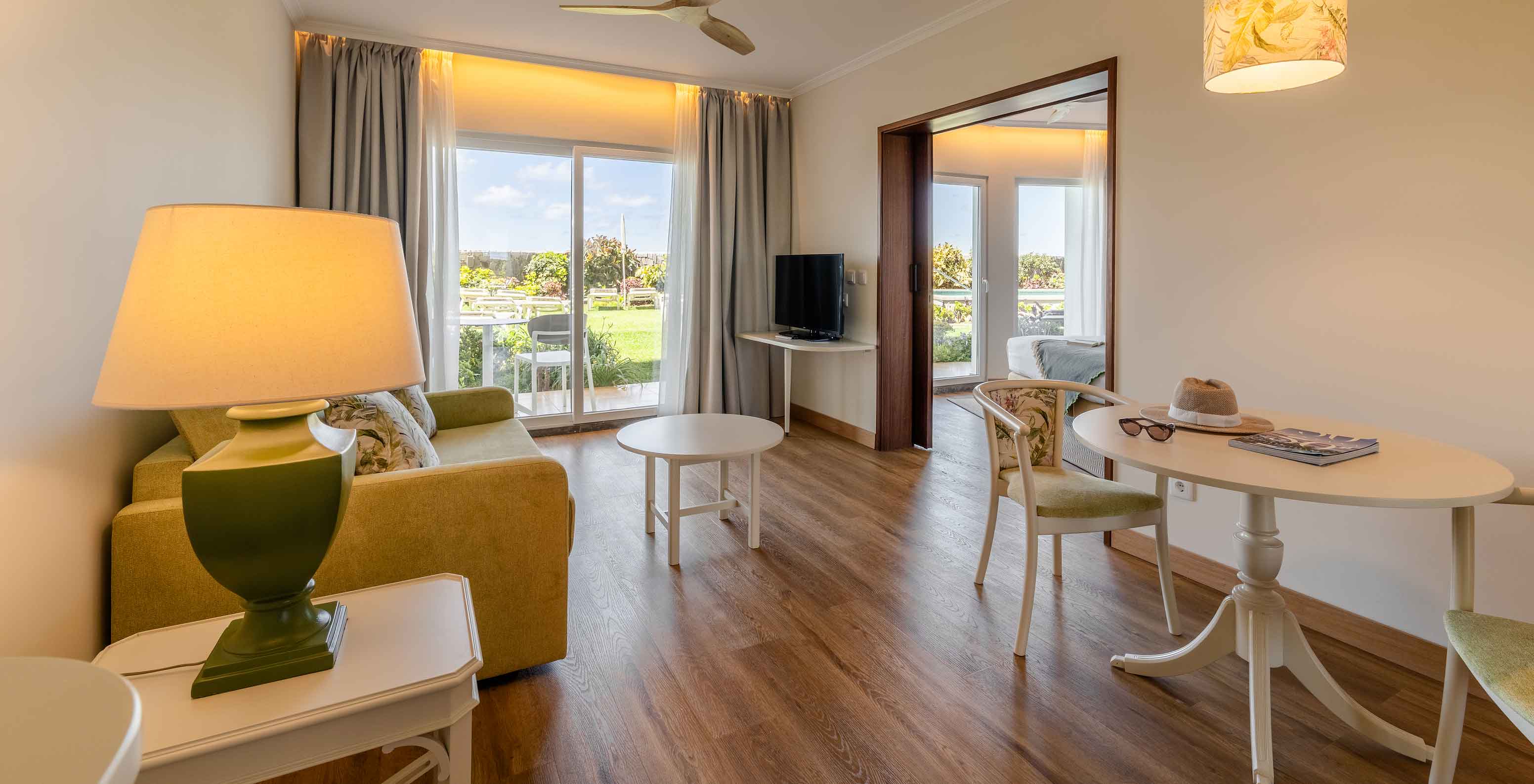 De Junior Suite Sea View van het Pestana Ocean Bay All Inclusive heeft een woonkamer met een bank en een eettafel