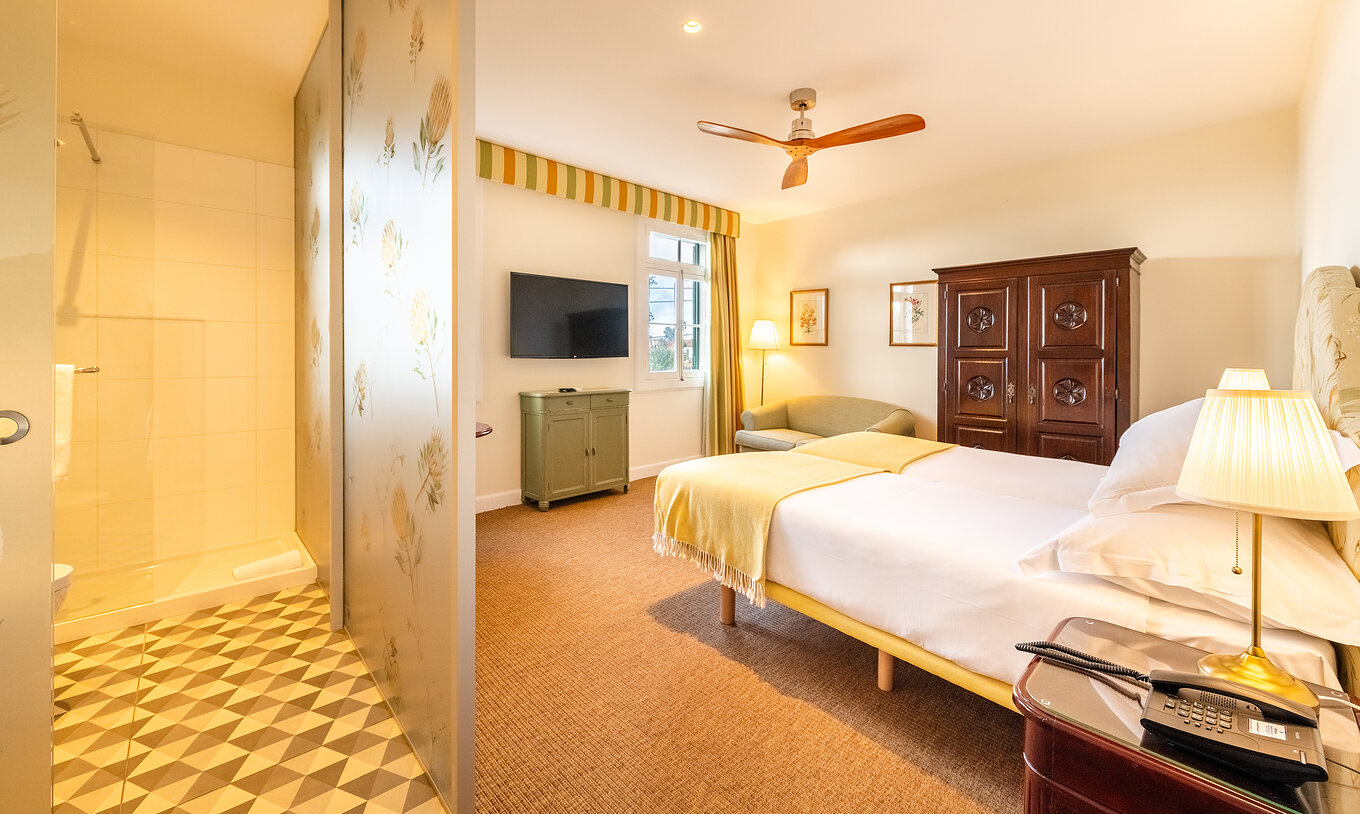 De Full Manor House van Pestana Quinta do Arco heeft twee bedden, houten kast, ventilator en scheidingswand met badkamer