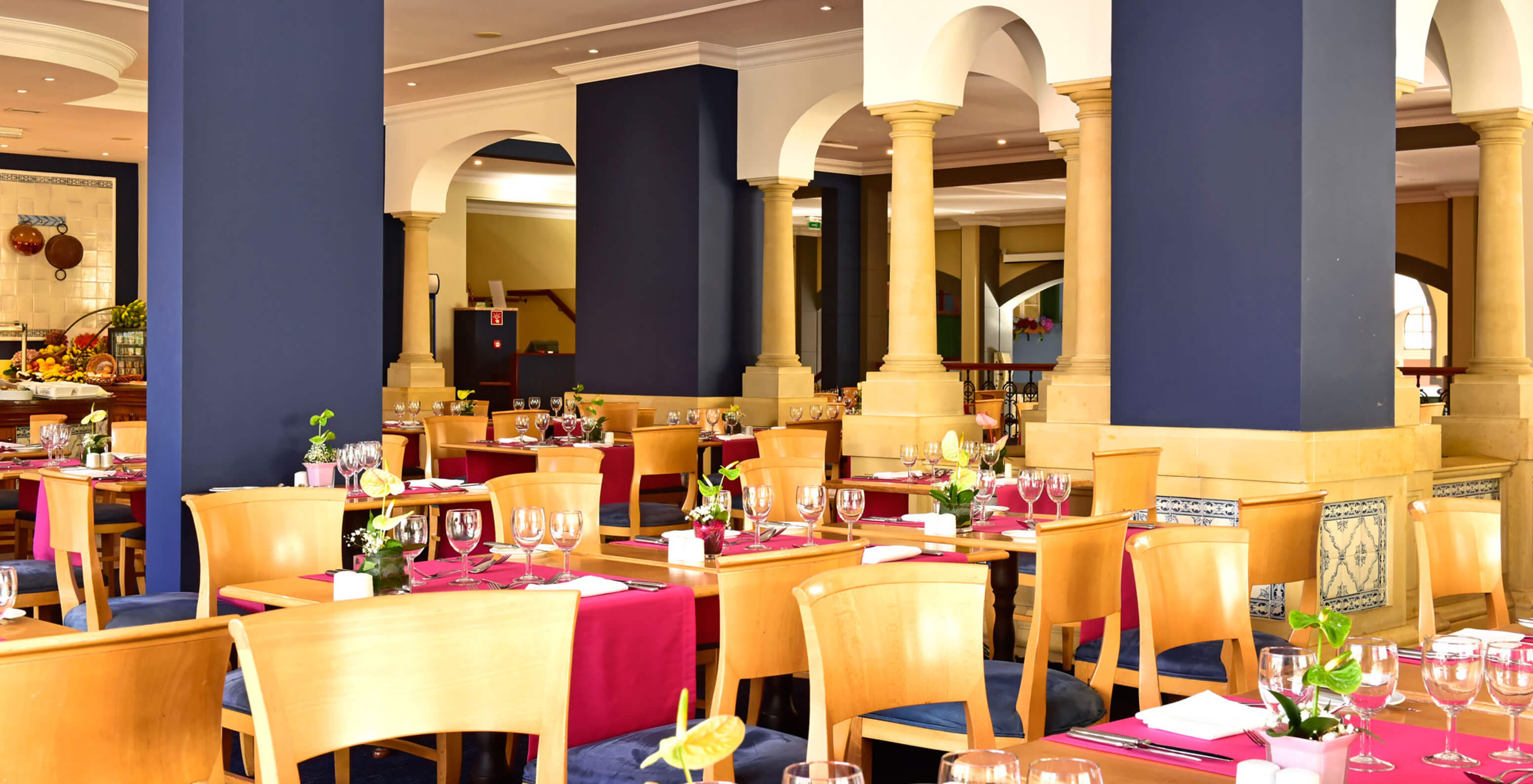 Het restaurant A Vila, Romantisch Hotel in Funchal, Madeira heeft verschillende tafels met houten stoelen