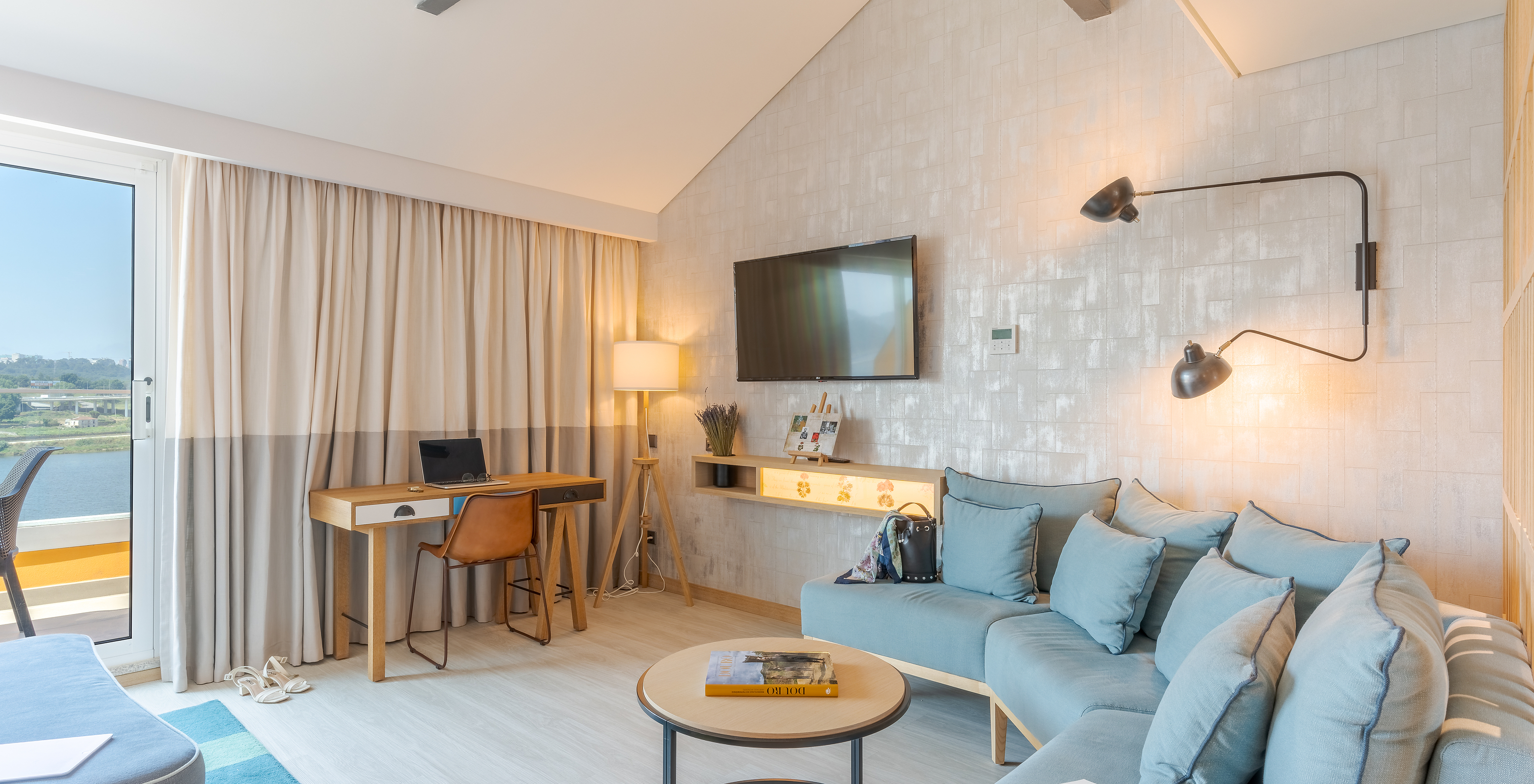 De Junior Suite van Pestana Douro Riverside heeft een televisie, bureau met tafel, en een bank