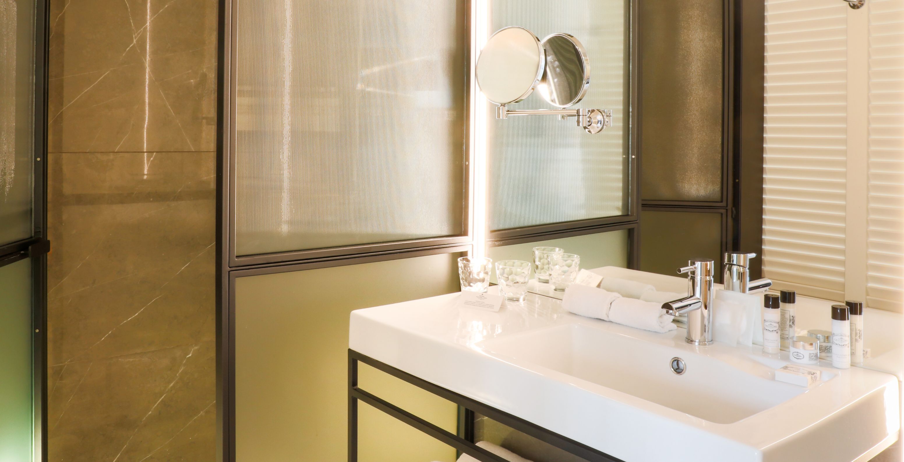 De Superior Plus Kamer in Pestana Collection Plaza Mayor heeft een badkamer met een grote spiegel en een inloopdouche.