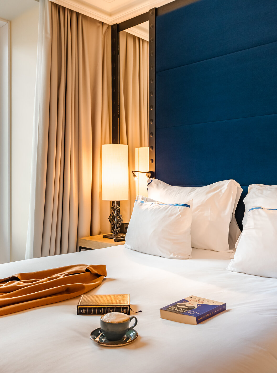 De Superior Plaza Mayor van Pestana Plaza Mayor Madrid heeft een tweepersoonsbed met blauwe hoofdeinde, spiegel en raam