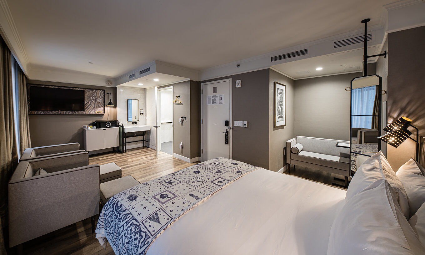 De Junior Suite - ADA van Pestana Park Avenue heeft een woonkamer met bank en fauteuils, kluis en televisie