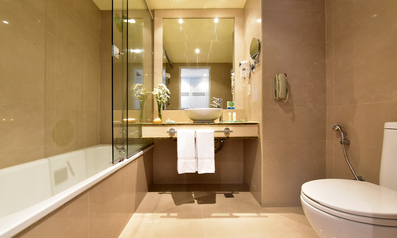 De Twin Executive van Pestana Caracas heeft een badkamer met douche, wastafel met spiegel, haardroger en toilet