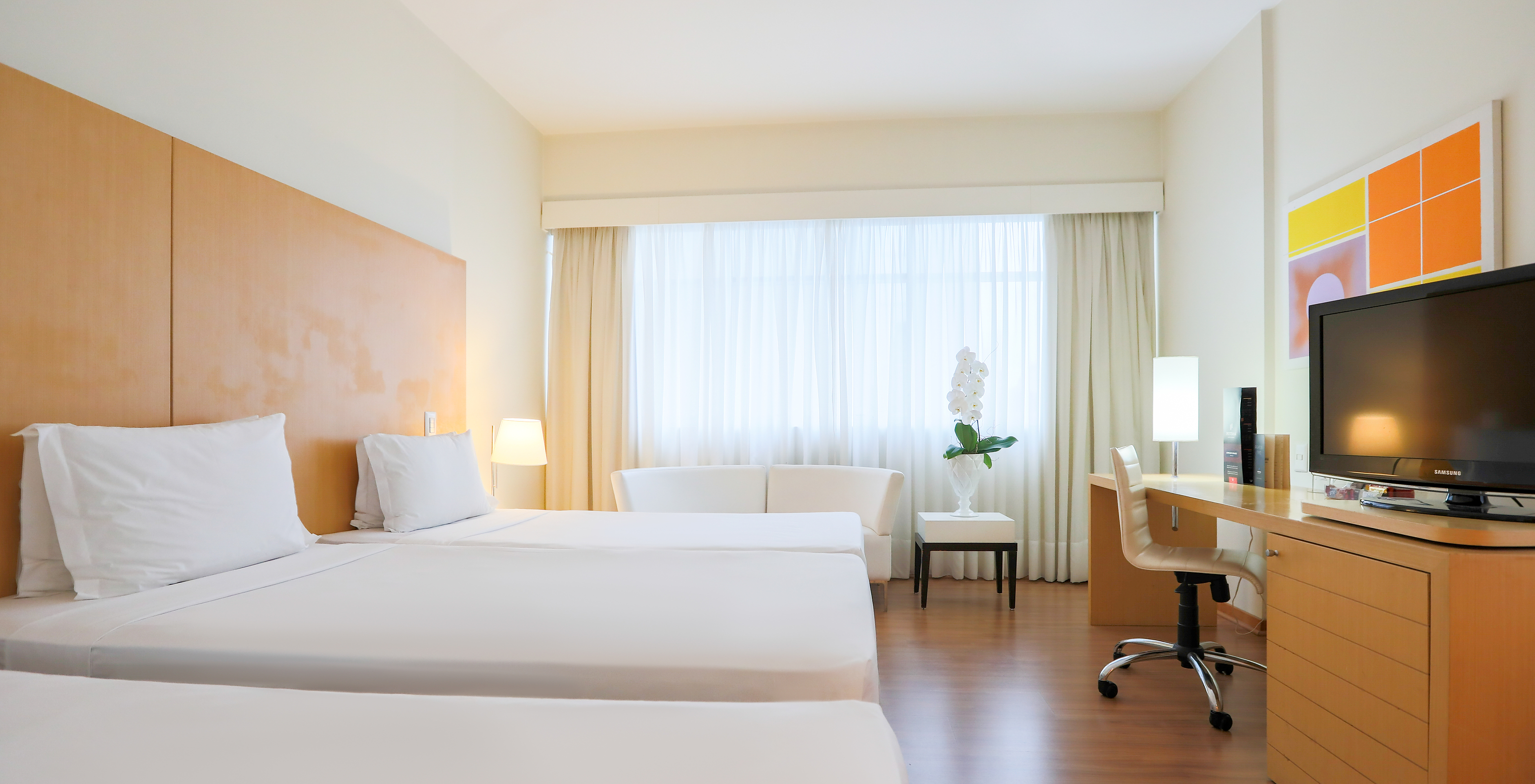 O Twin Luxo Corner do Pestana Curitiba tem capacidade para três pessoas com camas individuais e um sofá duplo junto à janela