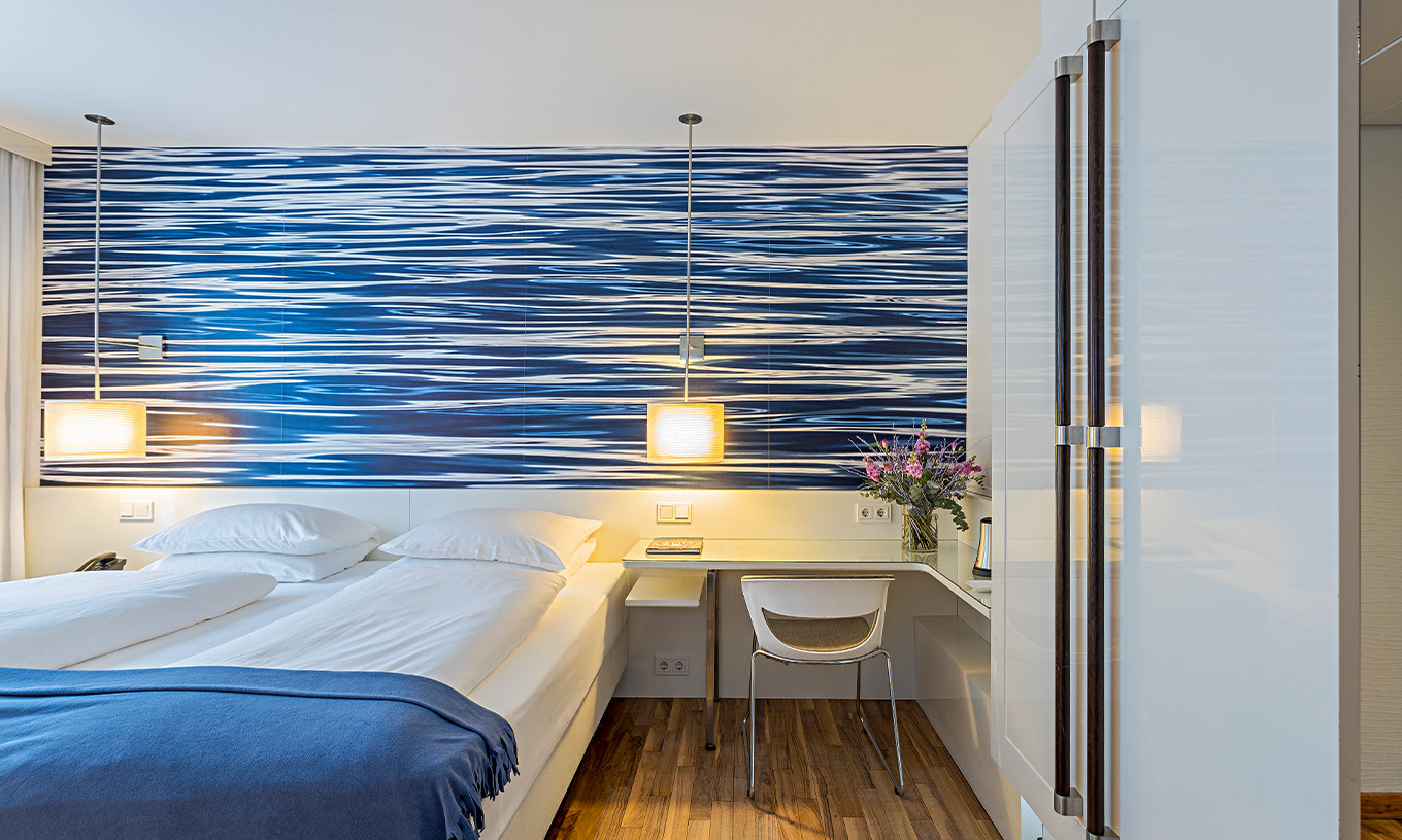 O Quarto Deluxe com Terraço do Pestana Berlin Tiergarten conta com uma cama de casal e uma secretária com candeeiro e cadeira