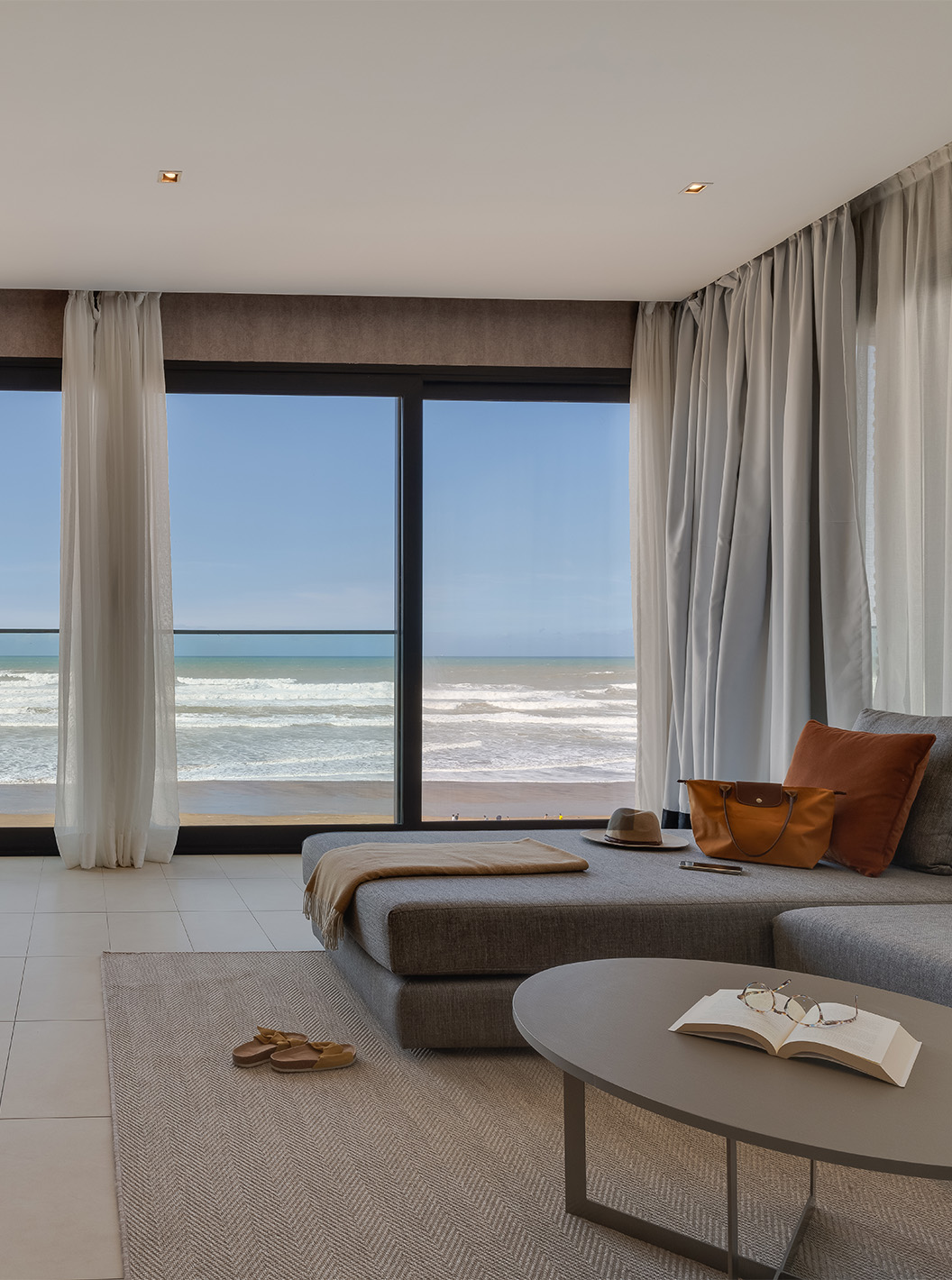 A Suite Familiar Corniche do Pestana Casablanca tem uma sala com sofa e uma vista espetacular sobre a praia