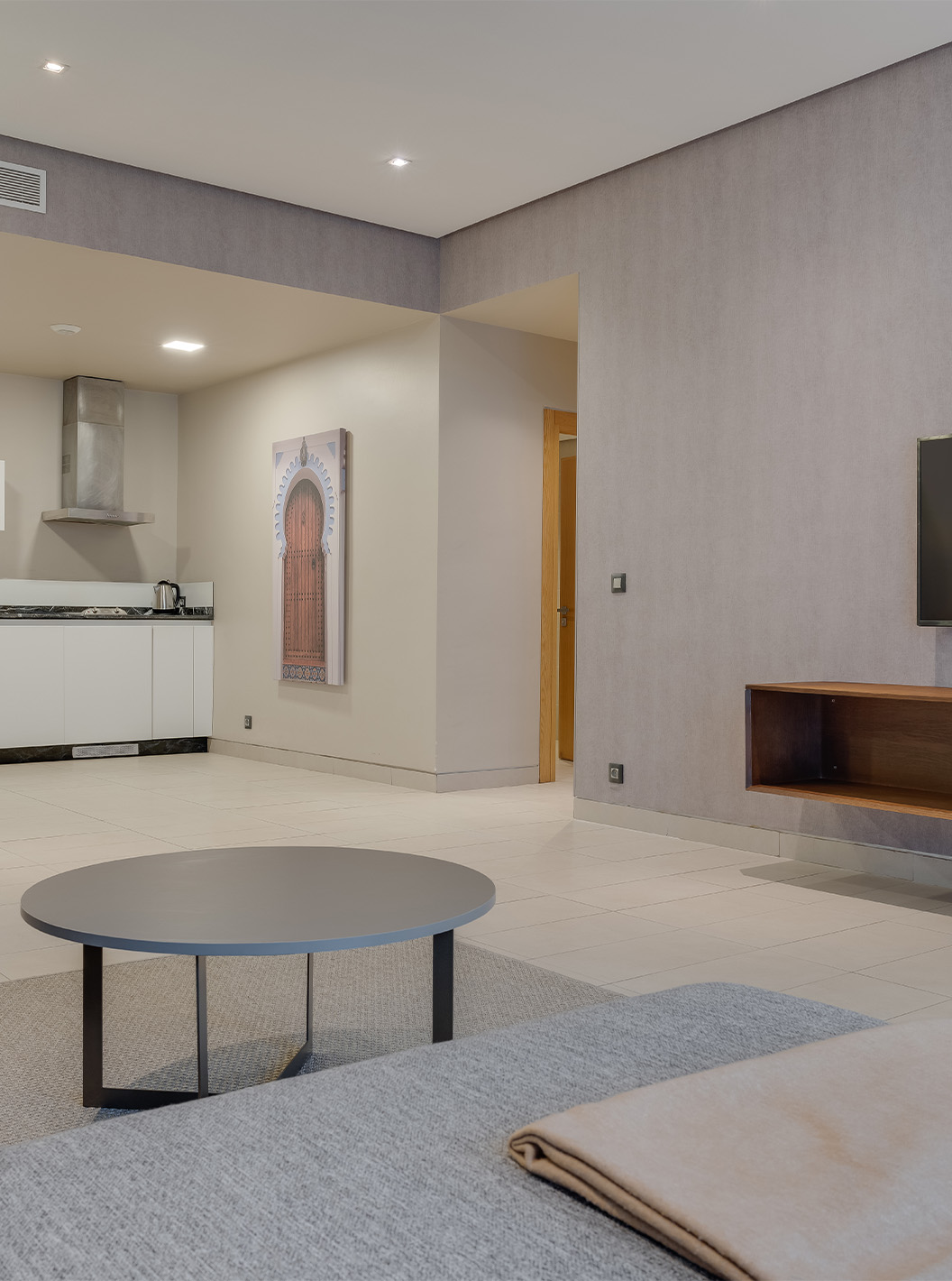 A Suite Familiar Premium do Pestana Casablanca tem um sofá confortável com chaise longue, uma televisão e uma kitchenette