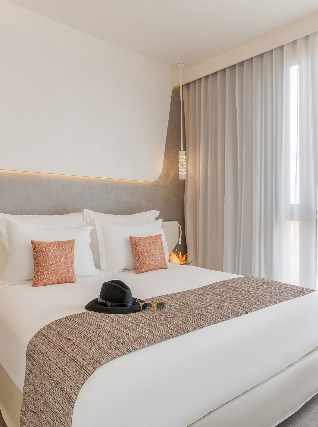 A CR7 Junior Suite Avenue do Pestana CR7 Marrakech tem uma janela, cama de casal com duas mesas de cabeceira e luz na parede