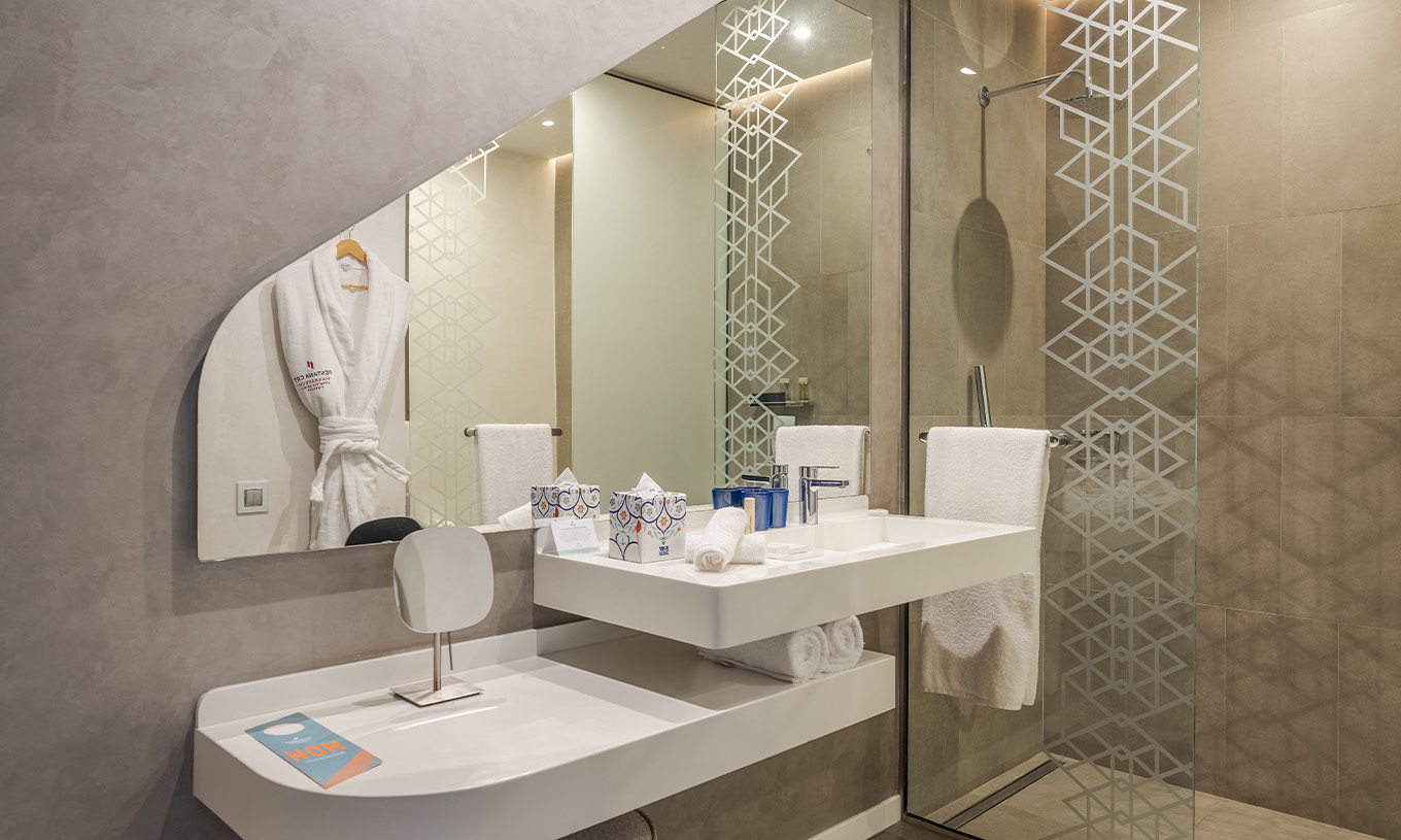 A CR7 Junior Suite do Pestana CR7 Marrakech tem uma casa de banho com walk-in shower, lavatório com espelho e prateleira