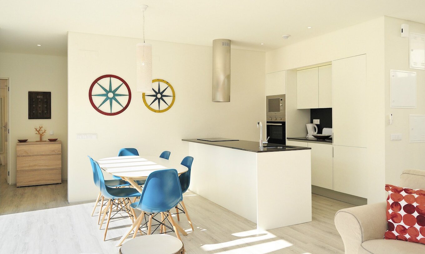 As Villas de 3 Quartos do Pestana Tróia Eco Resort têm uma cozinha com bancada e uma mesa com cadeiras