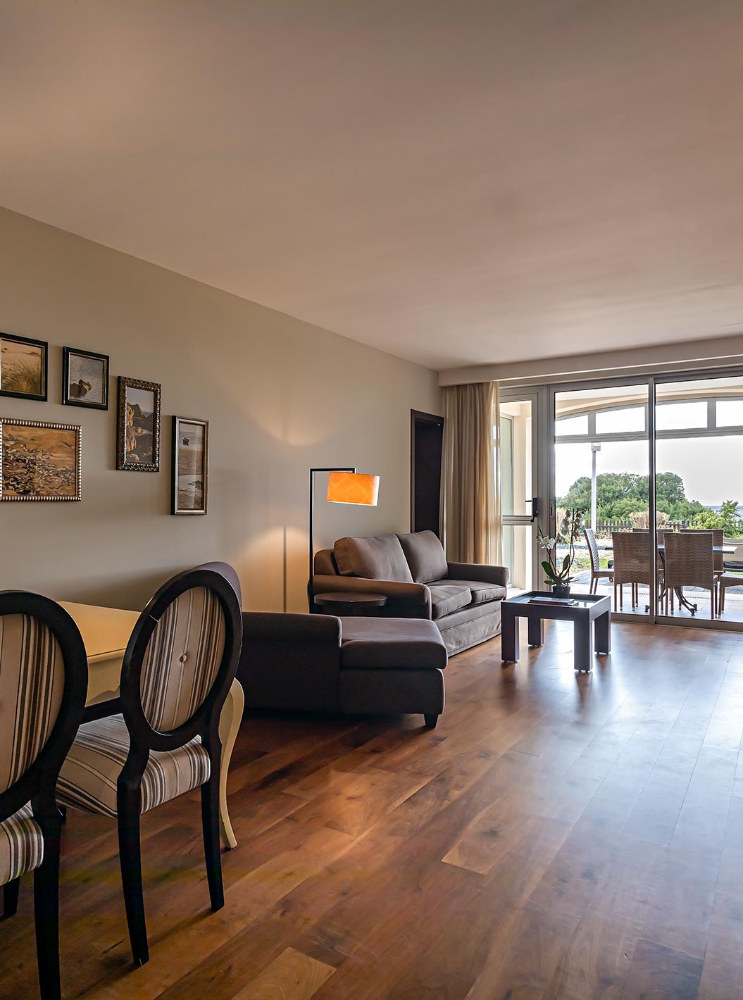 A Cliff Suite T2 do Pestana Alvor Praia tem uma sala de estar com dois sofás, uma televisão, uma mesa de jantar e um alpendre