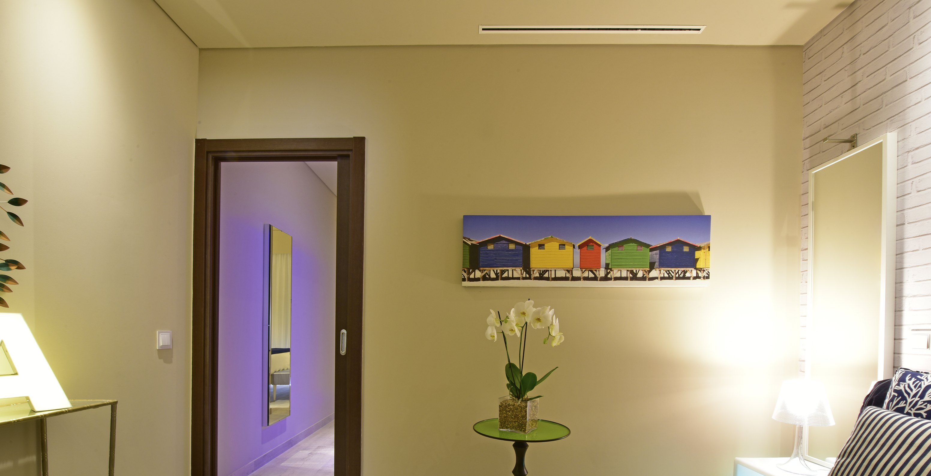 A Suite do Pestana Alvor South Beach tem uma pequena sala de estar com um sofá-cama. Decoração moderna e colorida