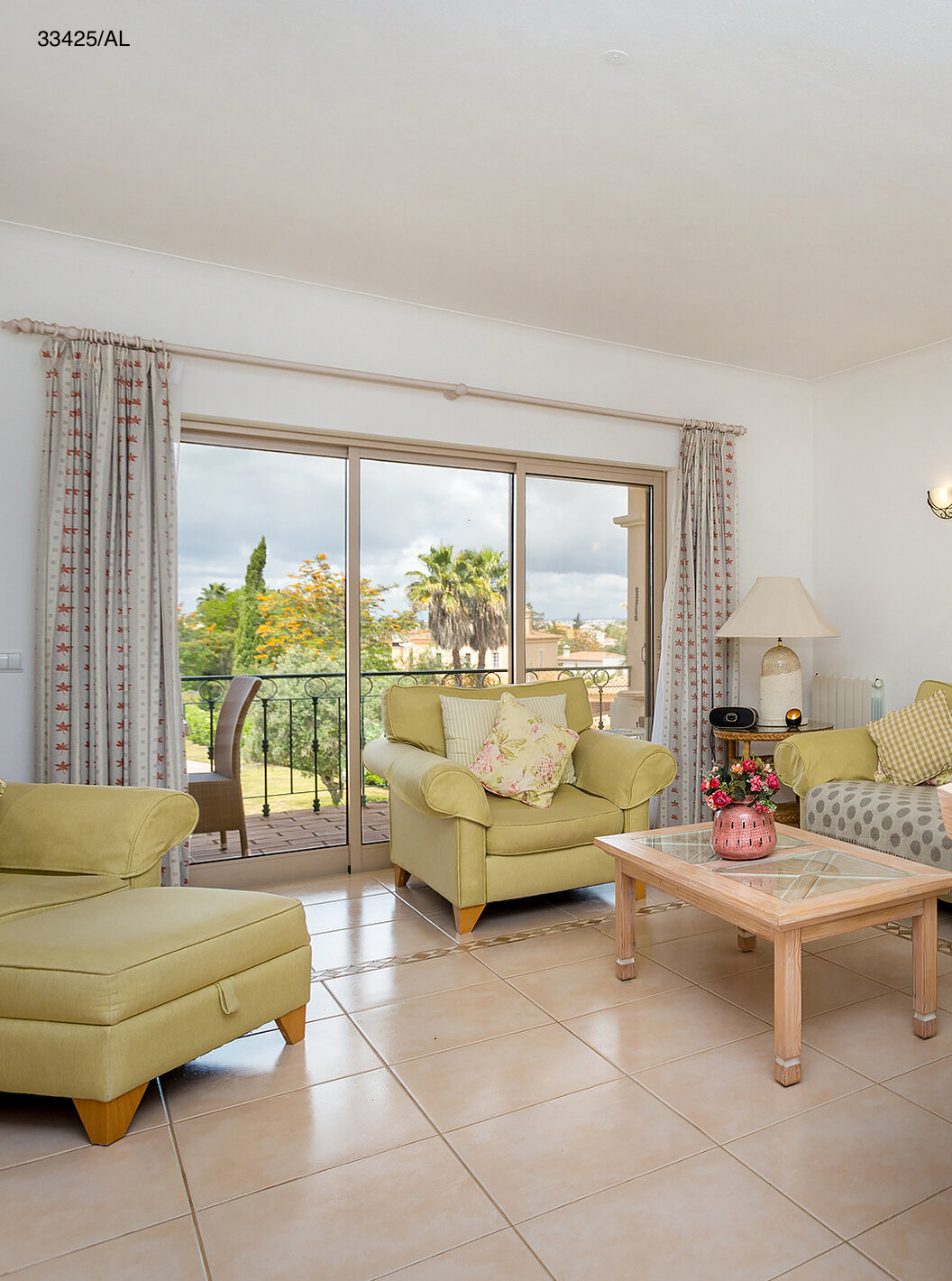 O Apartamento T2 Standart do Pestana Carvoeiro Golfe tem uma sala de estar com sofás verdes e uma mesa redonda