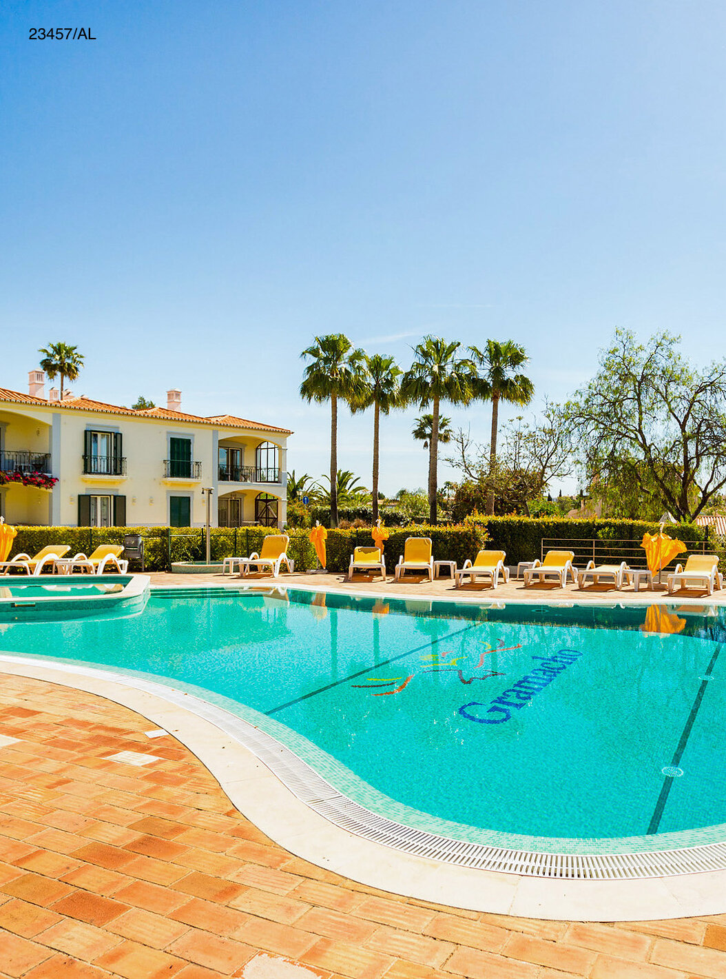 O Apartamento T3 Standart do Pestana Carvoeiro Golfe tem um pátio exterior com piscina e espreguiçadeiras amarelas