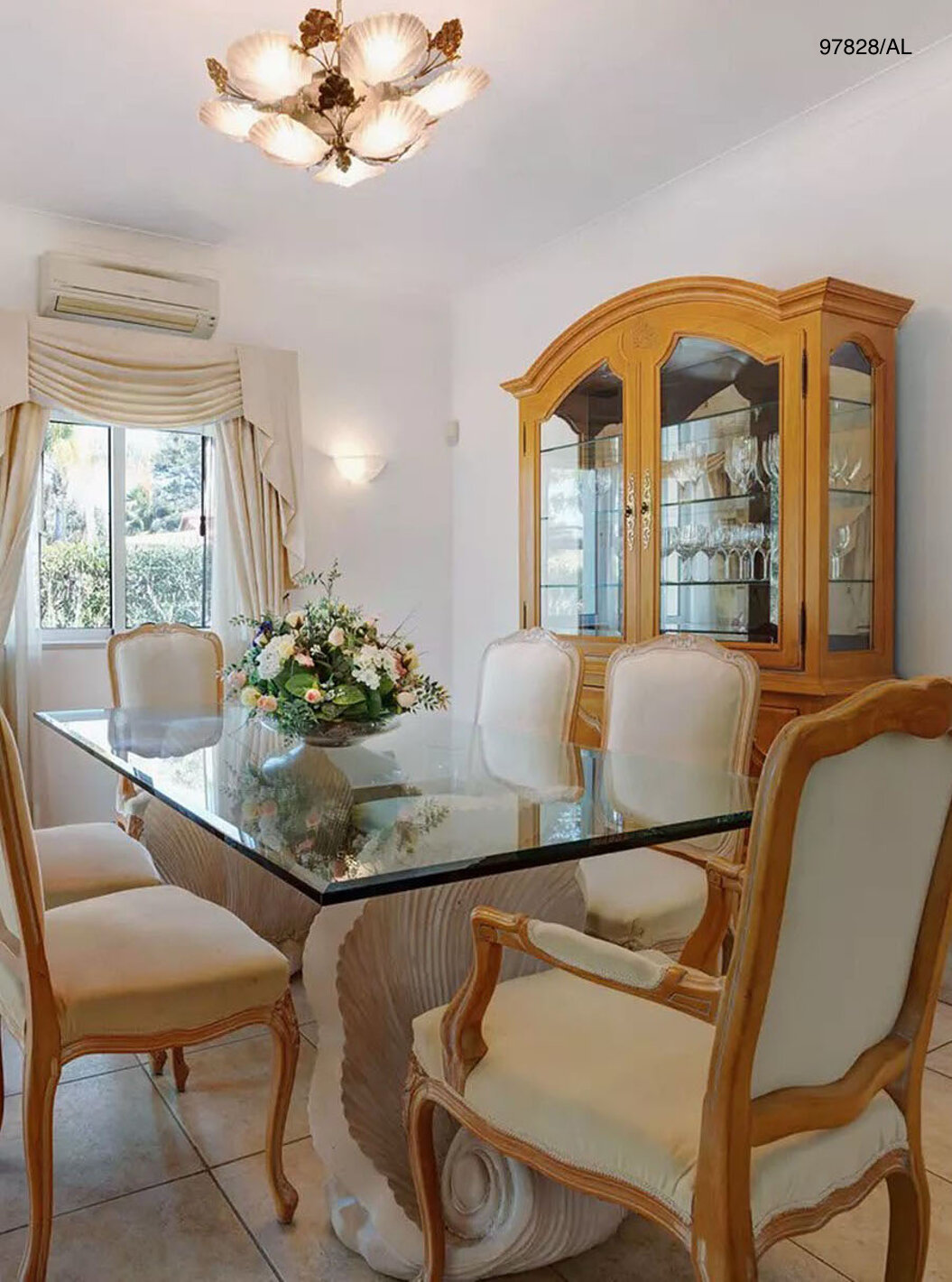 A Moradia V3 Standart do Pestana Carvoeiro Golfe tem uma sala de jantar com uma mesa de vidro, cadeiras e um armário