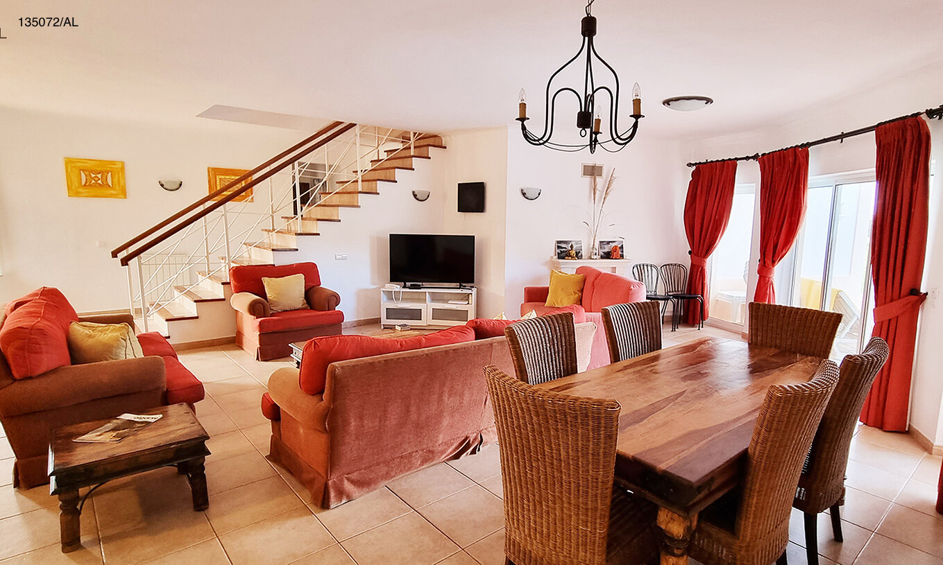 A Moradia V3 Standart do Pestana Carvoeiro Golfe tem uma sala de estar com sofás e cadeirões, e uma mesa com cadeiras