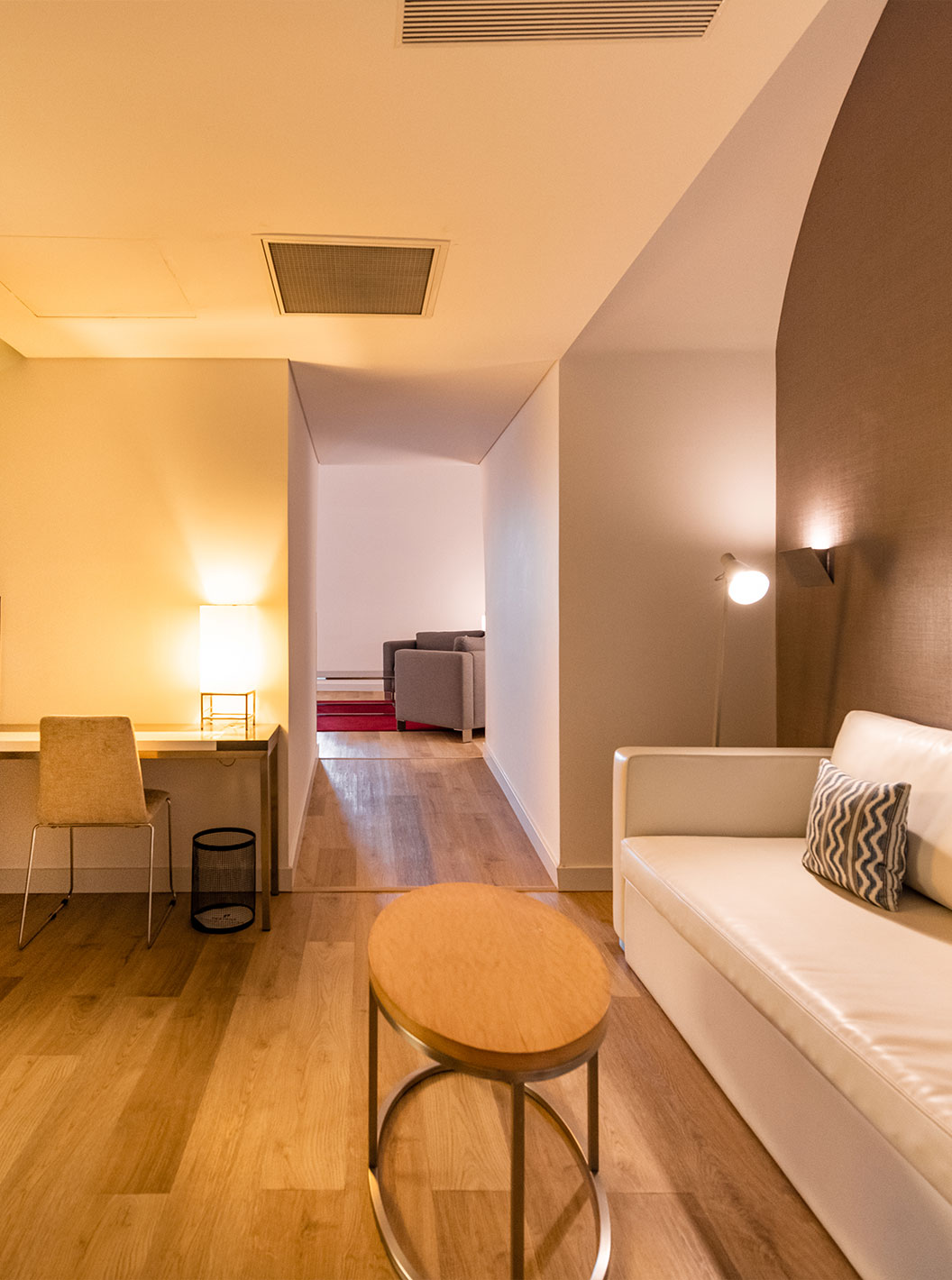 A Junior Suite Familiar do Pestana Cidadela Cascais tem uma sala com um sofá, uma mesa de apoio e uma secretária