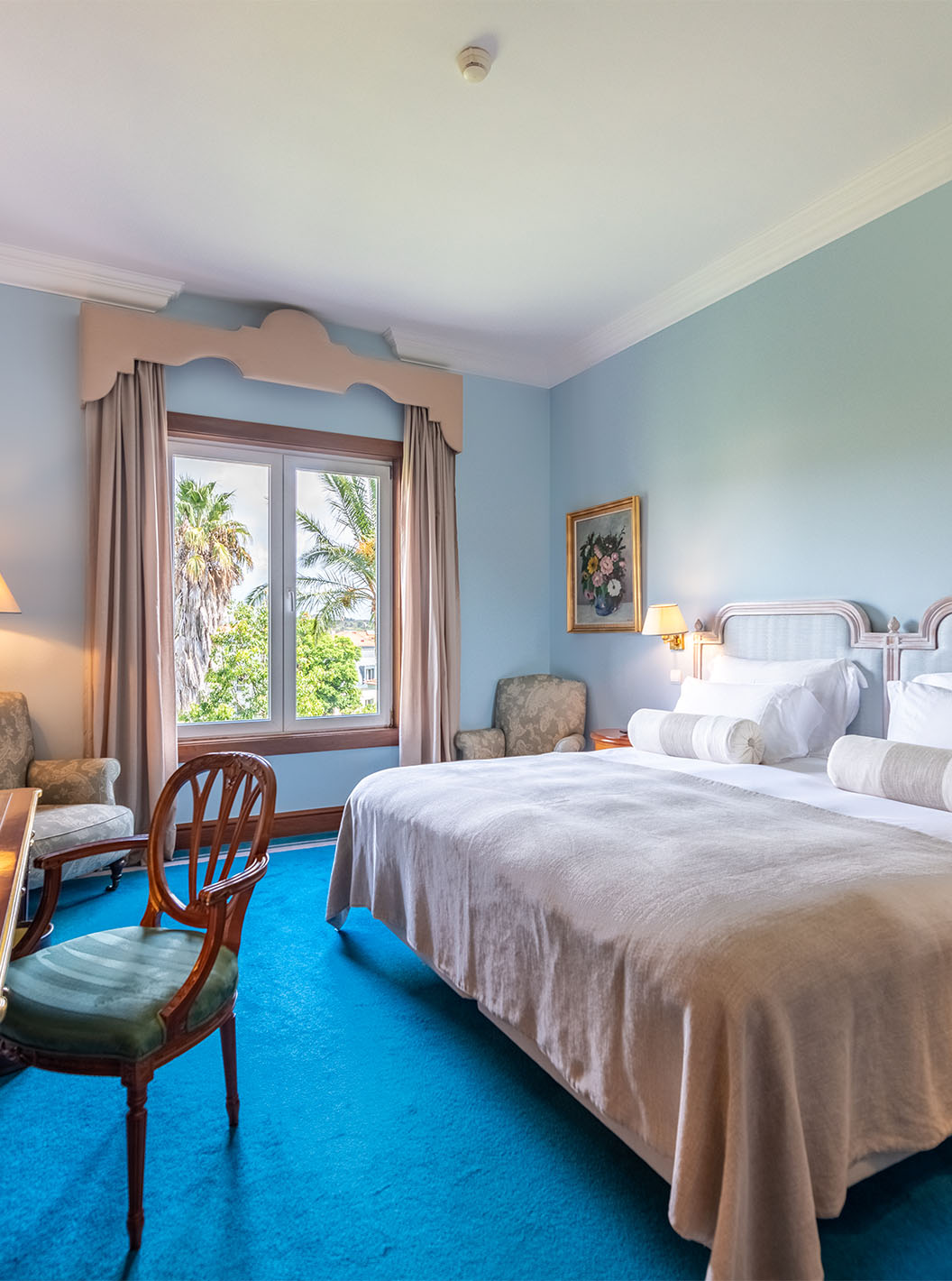 O Deluxe Garden do Pestana Palace Lisboa tem uma cama de casal, duas mesas de cabeceira, secretária e janela com vista jardim