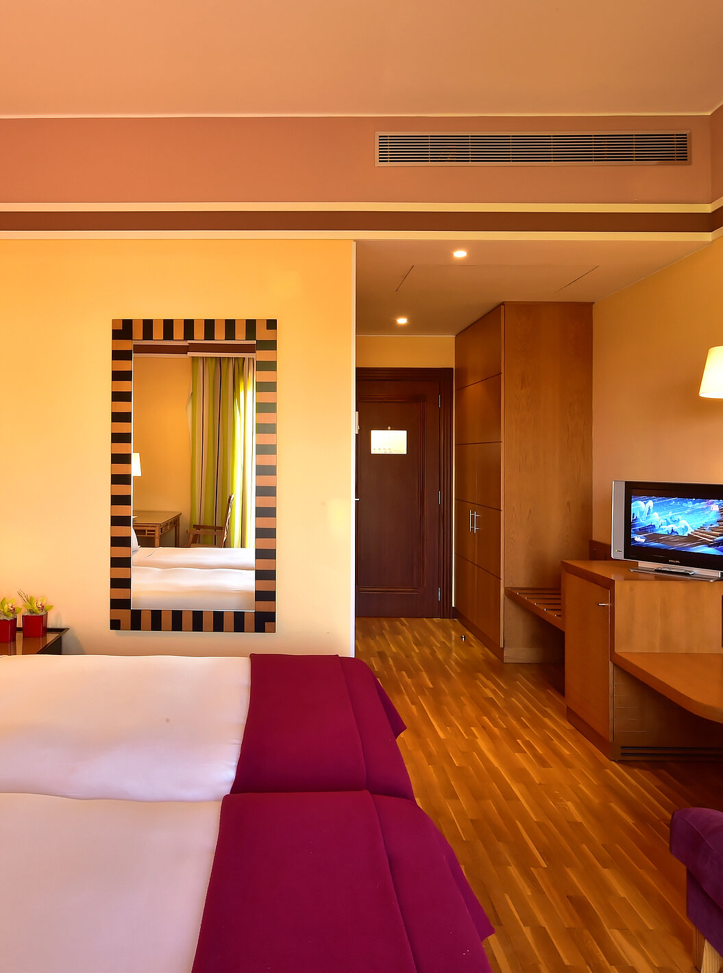 O Duplo Clássico - Vista Jardim do Pestana Sintra Golf tem duas camas, um espelho na parede, uma televisão e um sofá