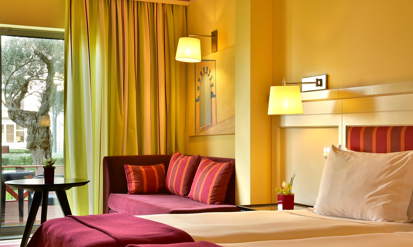 O Duplo Superior do Pestana Sintra Golf tem duas camas, um sofá com uma mesa de apoio e uma janela com cortinas