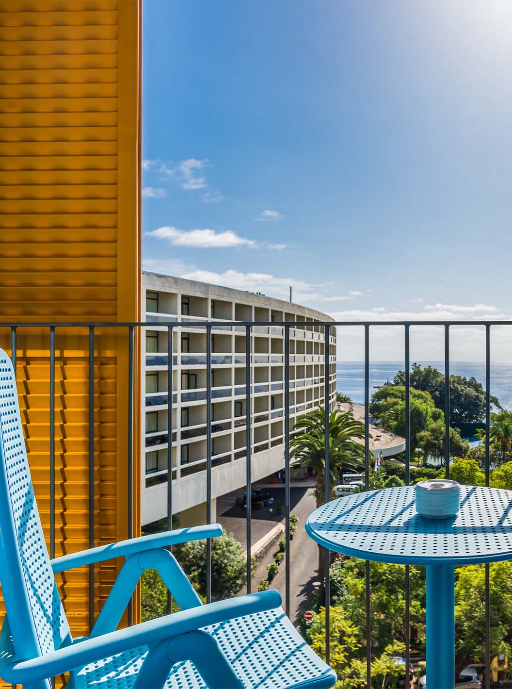 O Estúdio Deluxe Vista Mar do Pestana Casino Studios tem uma varanda com vista para a cidade e uma mesa com cadeiras azuis