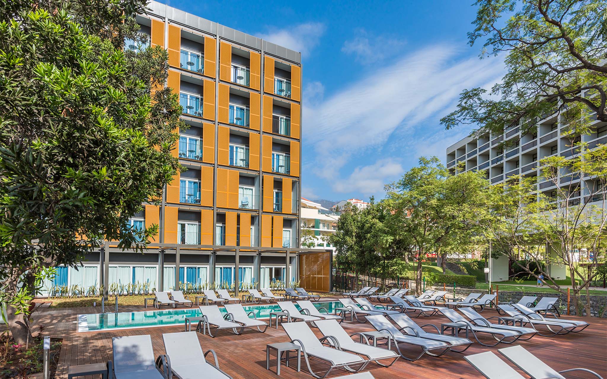 Vista do exterior do Pestana Casino Studios, com Apartamentos no Centro da Cidade, com Piscina e um edifício laranja