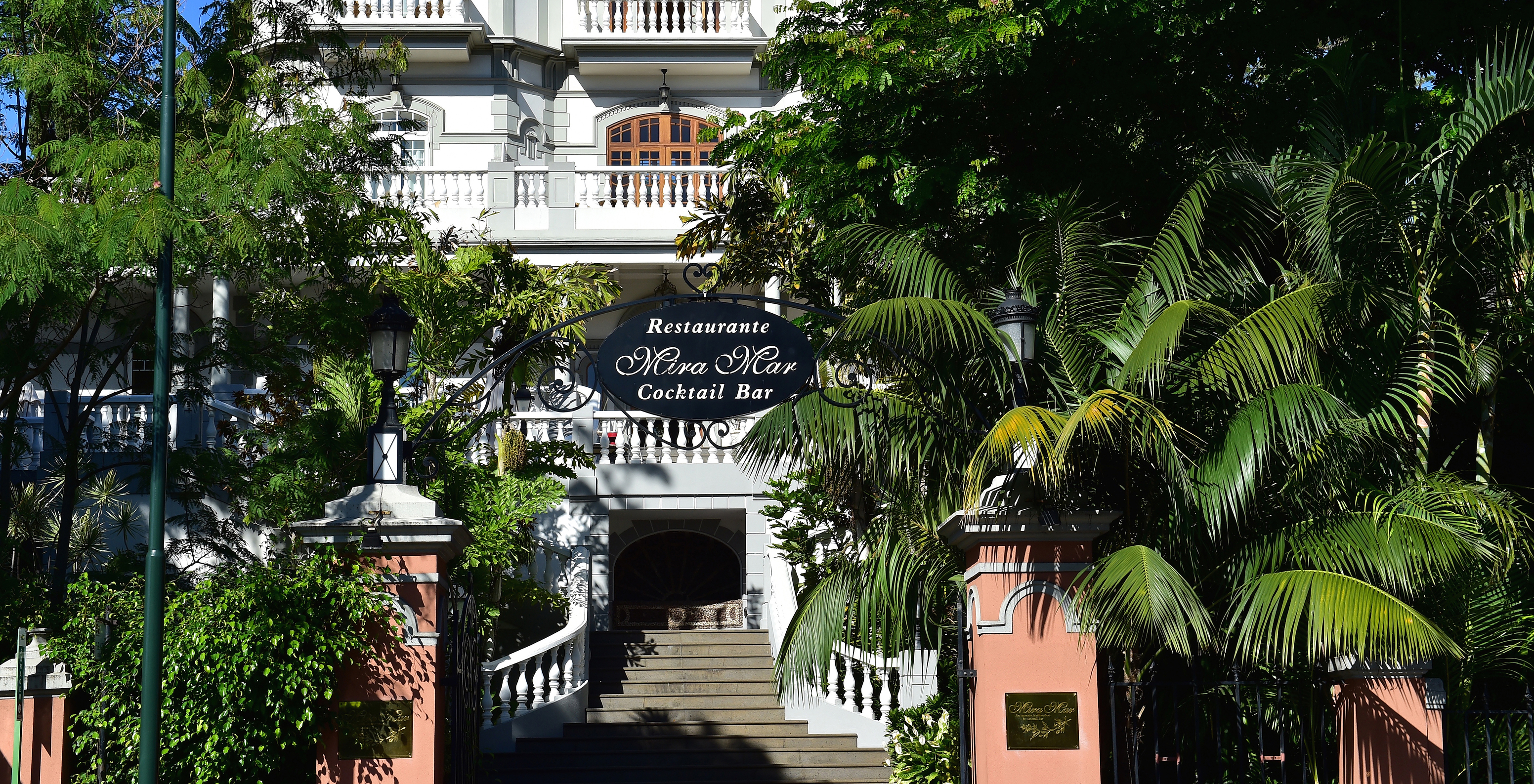 Fachada do restaurante da Quinta Miramar, um edifício branco imponente no meio da vegetação, ideal para eventos