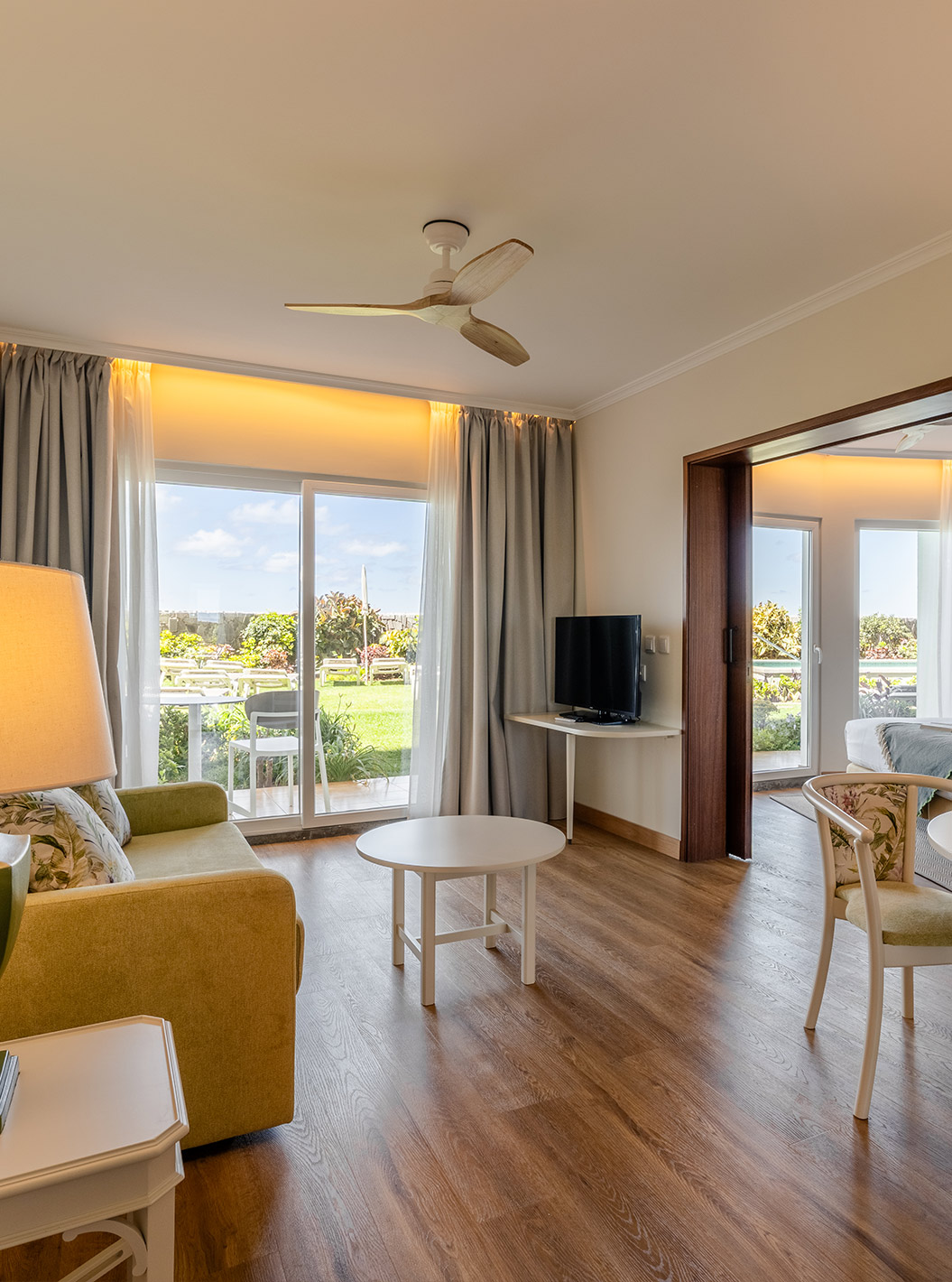 O Junior Suite Sea View  do Pestana Ocean Bay All Inclusive tem uma sala luminosa, com sofá, mesa de centro e de refeições  