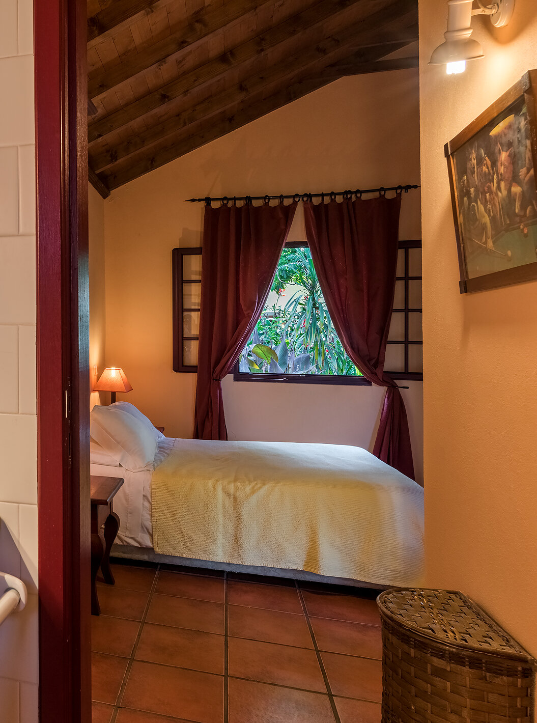 As Villas do Pestana Quinta do Arco têm casa de banho com lavatório e a porta aberta para o quarto com cama de casal 