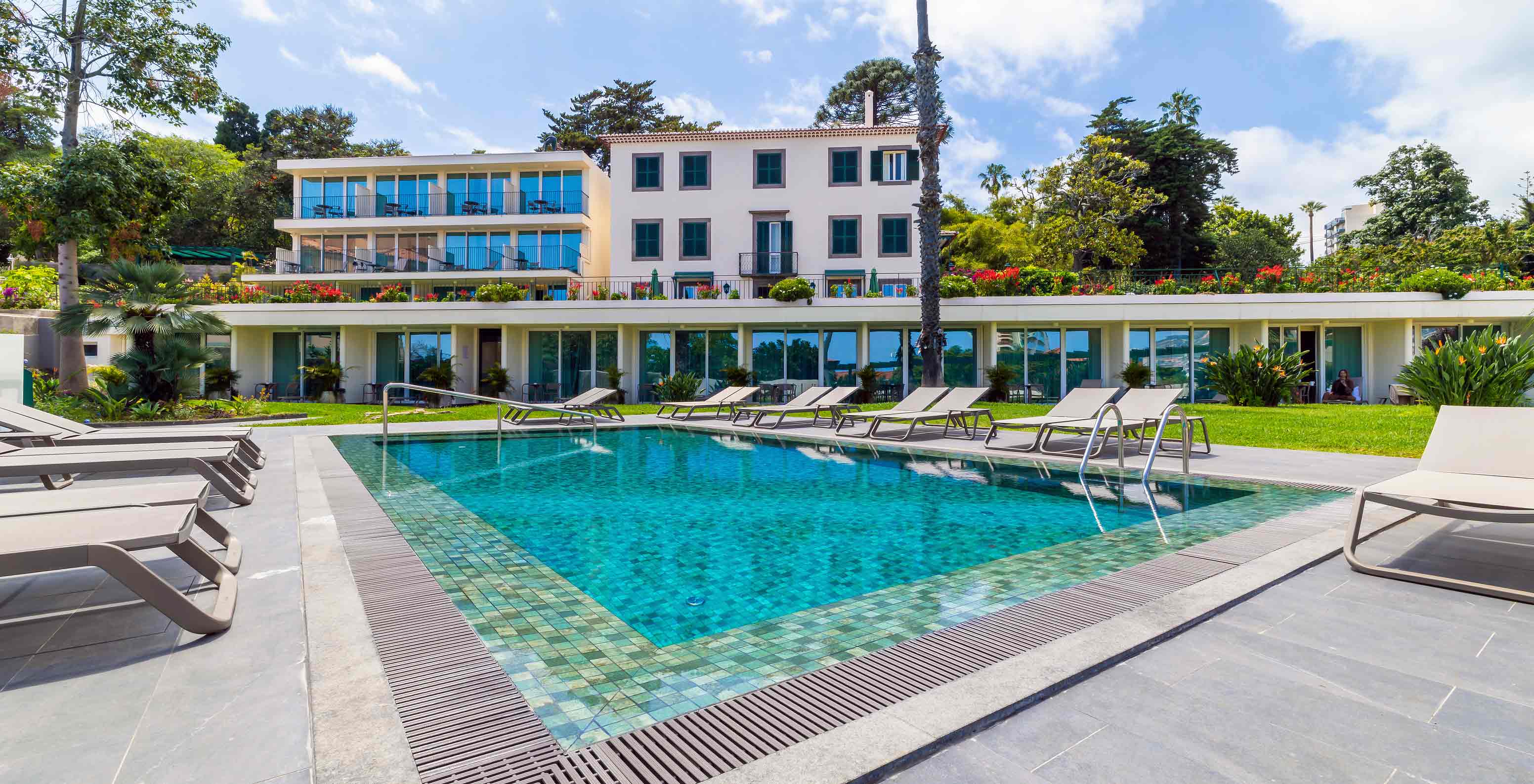 Fachada do Hotel Pestana Quinta Perestrello com vista para a piscina e para a zona das espreguiçadeiras 