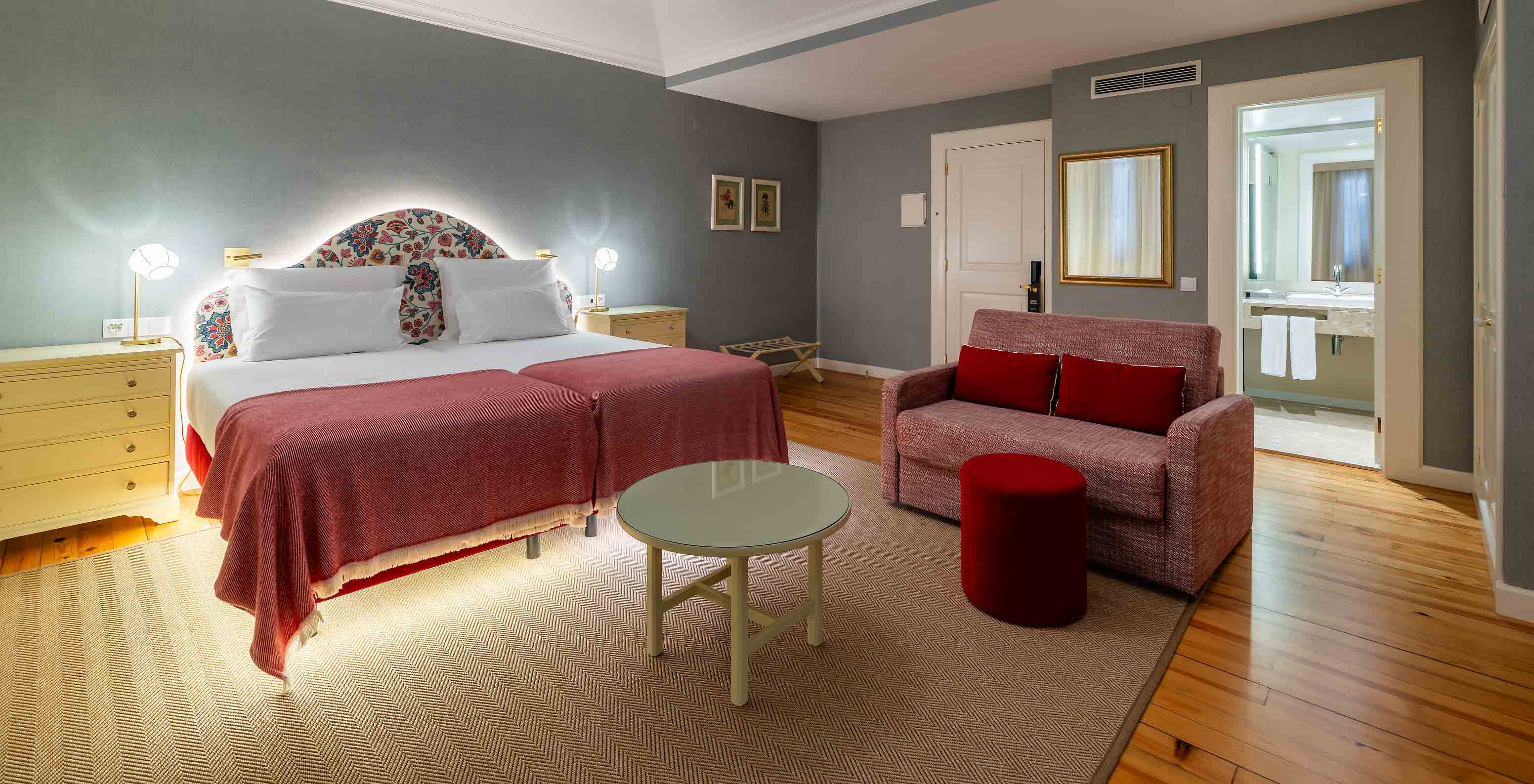 O Quarto Junior Suite Vista Mar Parcial do Pestana Quinta Perestrello tem uma cama de casal, um sofá e um espelho