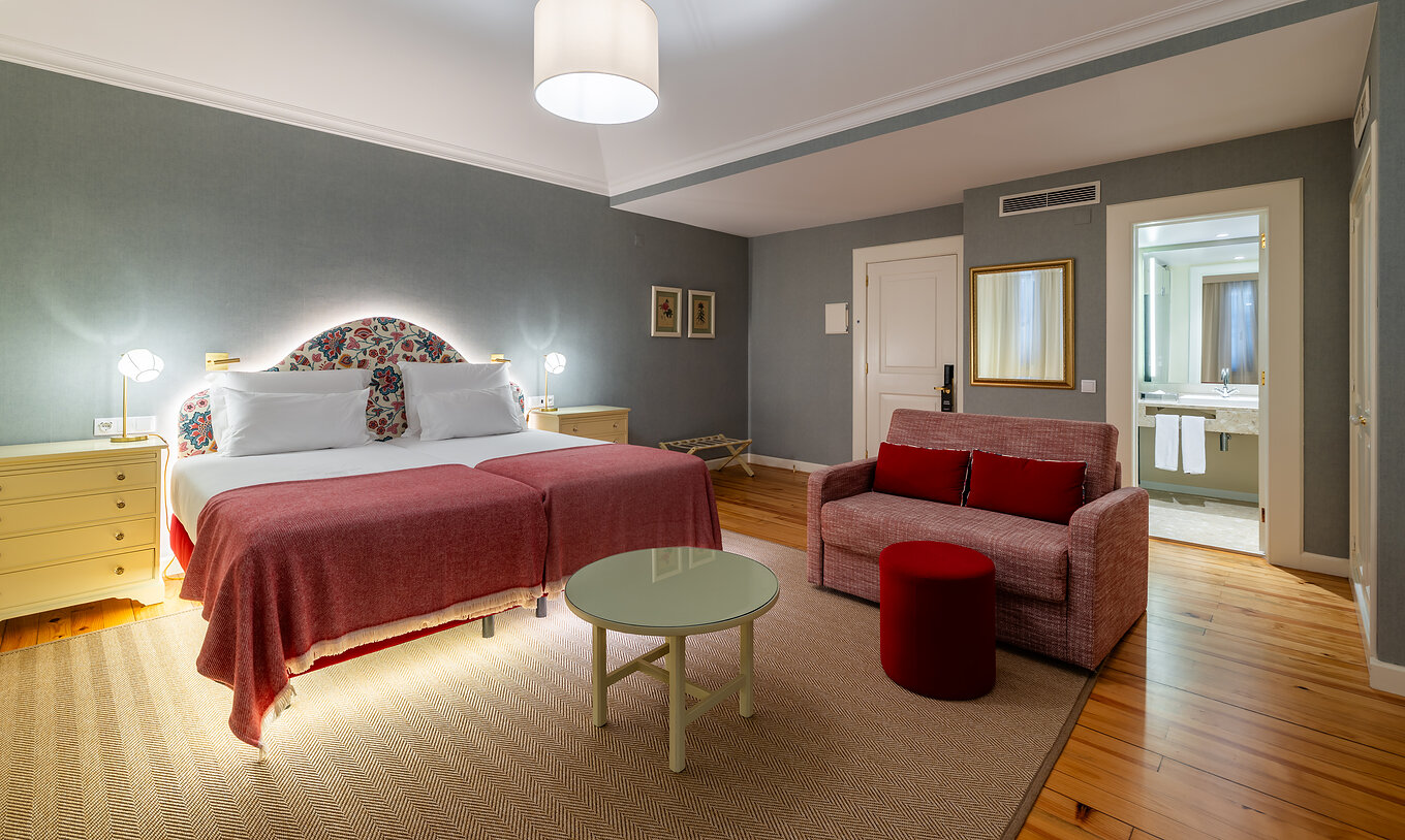 O Quarto Junior Suite Vista Mar Parcial do Pestana Quinta Perestrello tem uma cama de casal, um sofá e um espelho