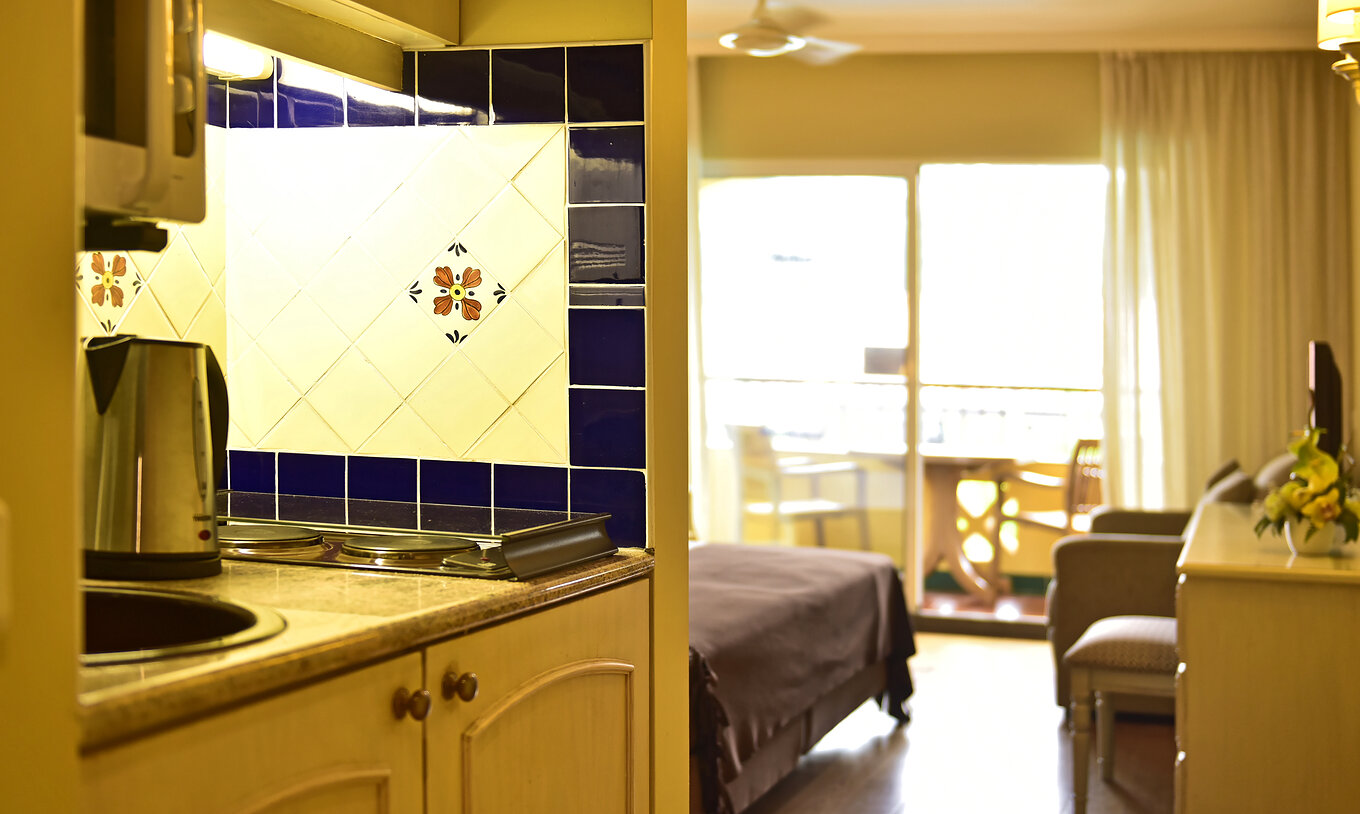 O Studio Classic do Pestana Village tem uma cozinha com bicos de fogão e chaleira, com varanda e cama de casal