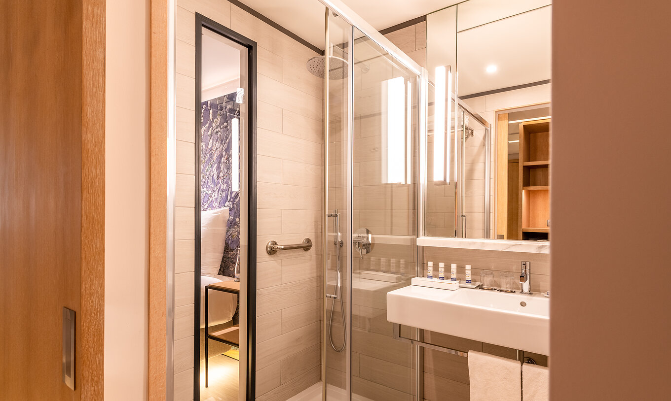 O quarto Deluxe River View do Pestana Douro Riverside conta uma casa de banho com lavatório, espelho e chuveiro