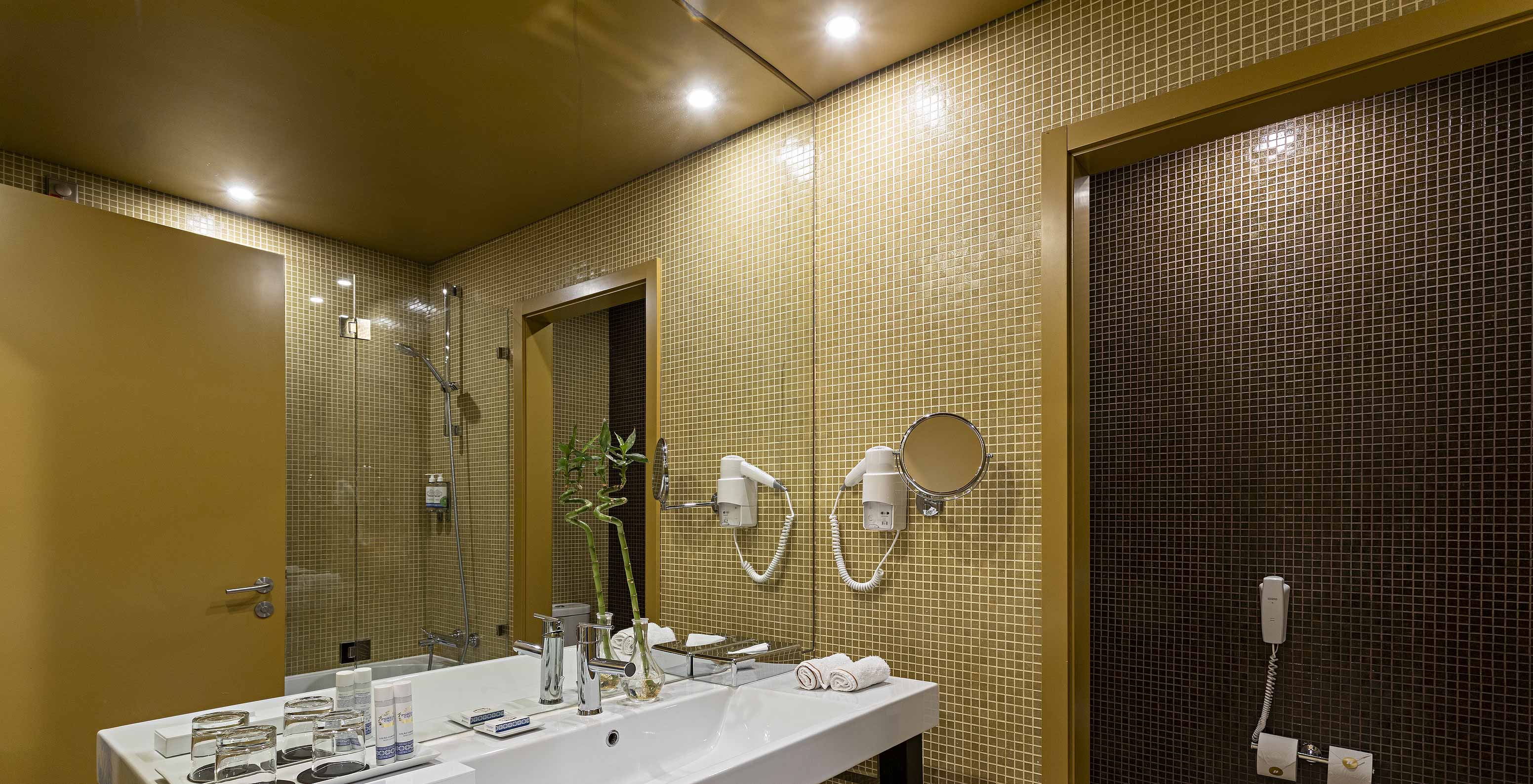 O Executive do Pestana Palácio do Freixo tem uma casa de banho com azulejos amarelos e castanhos
