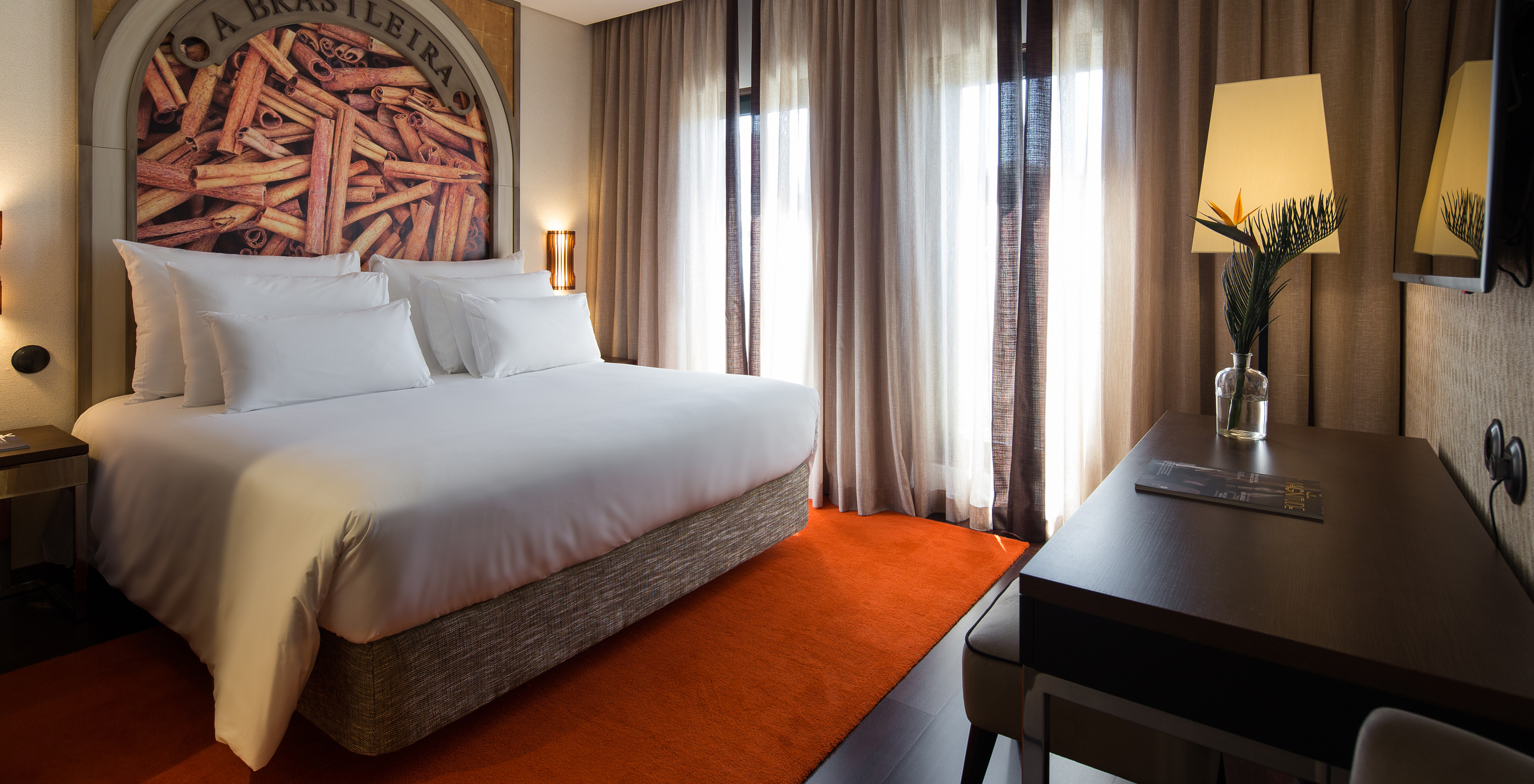 O Deluxe Executive Grand View do Pestana Porto - A Brasileira tem uma cama king size com um mural temático sobre a canela