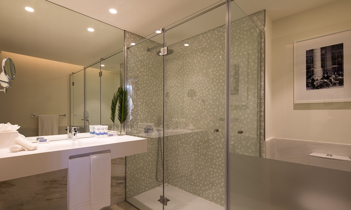 A Master Suite do Pestana Porto - A Brasileira tem uma casa de banho com poliban com duche e uma lavatório grande