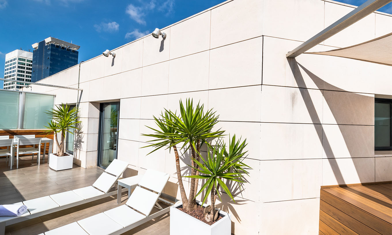 A Junior Suite do Pestana Arena Barcelona tem um terraço no rooftop com espreguiçadeiras e plantas para relaxar