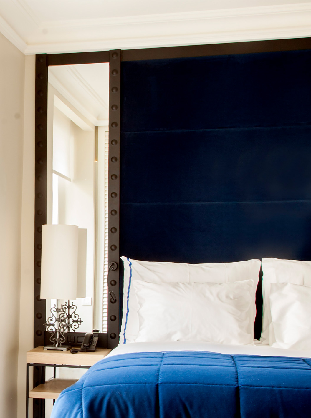 O Quarto Superior do Pestana Plaza Mayor Madrid tem uma cama de casal com cabeceira azul com espelho e um lavatório