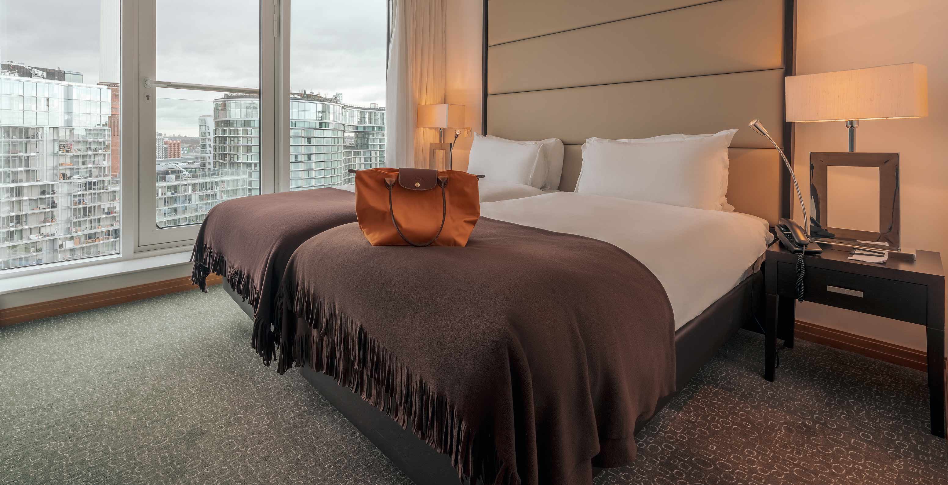 O Superior Twin do Pestana Chelsea Bridge tem cama de casal, mesas de cabeceira com candeeiro e janela com vista cidade