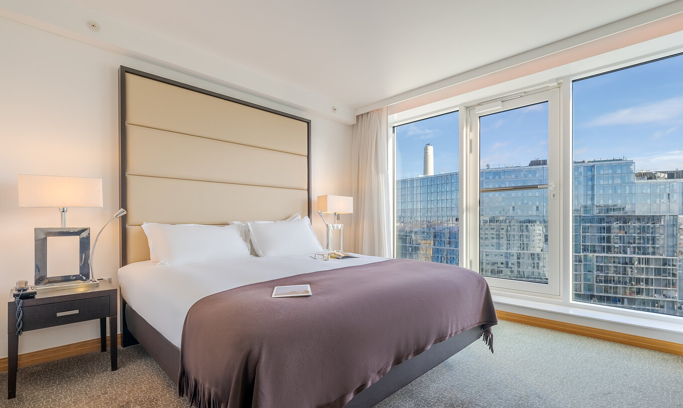 O Superior King do Pestana Chelsea Bridge tem cama de casal com lençóis brancos e janela grande com vista para a cidade