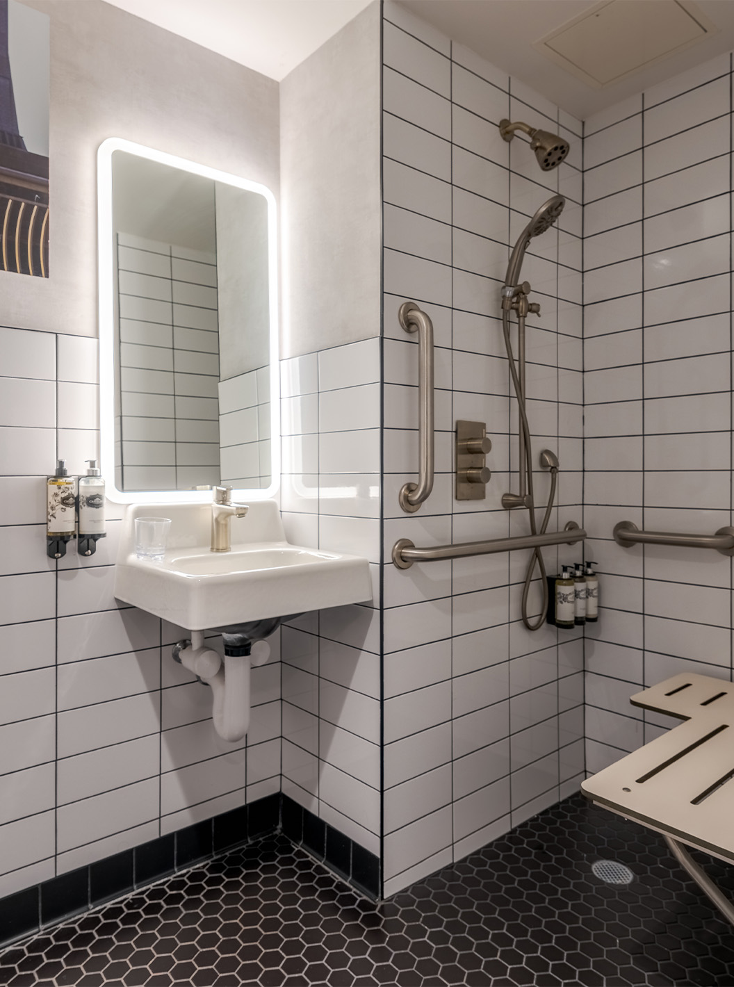 O Comfort Room ADA do Pestana CR7 Times Square tem uma casa de banho adaptada com duche, lavatório, e espelho